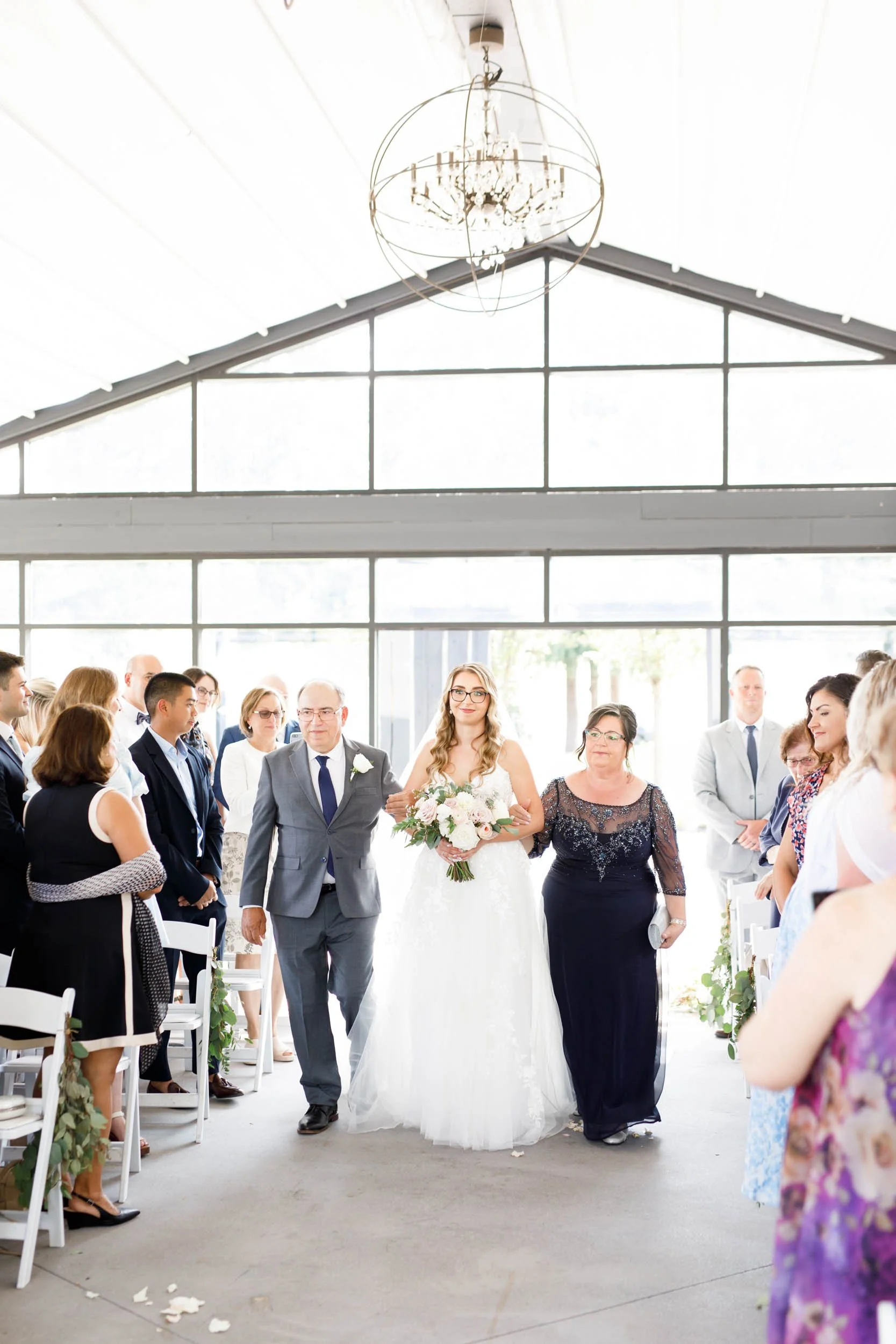 Bride walking down the aisle during ceremony at Whistle Bear Golf Club wedding in Cambridge, Ontario