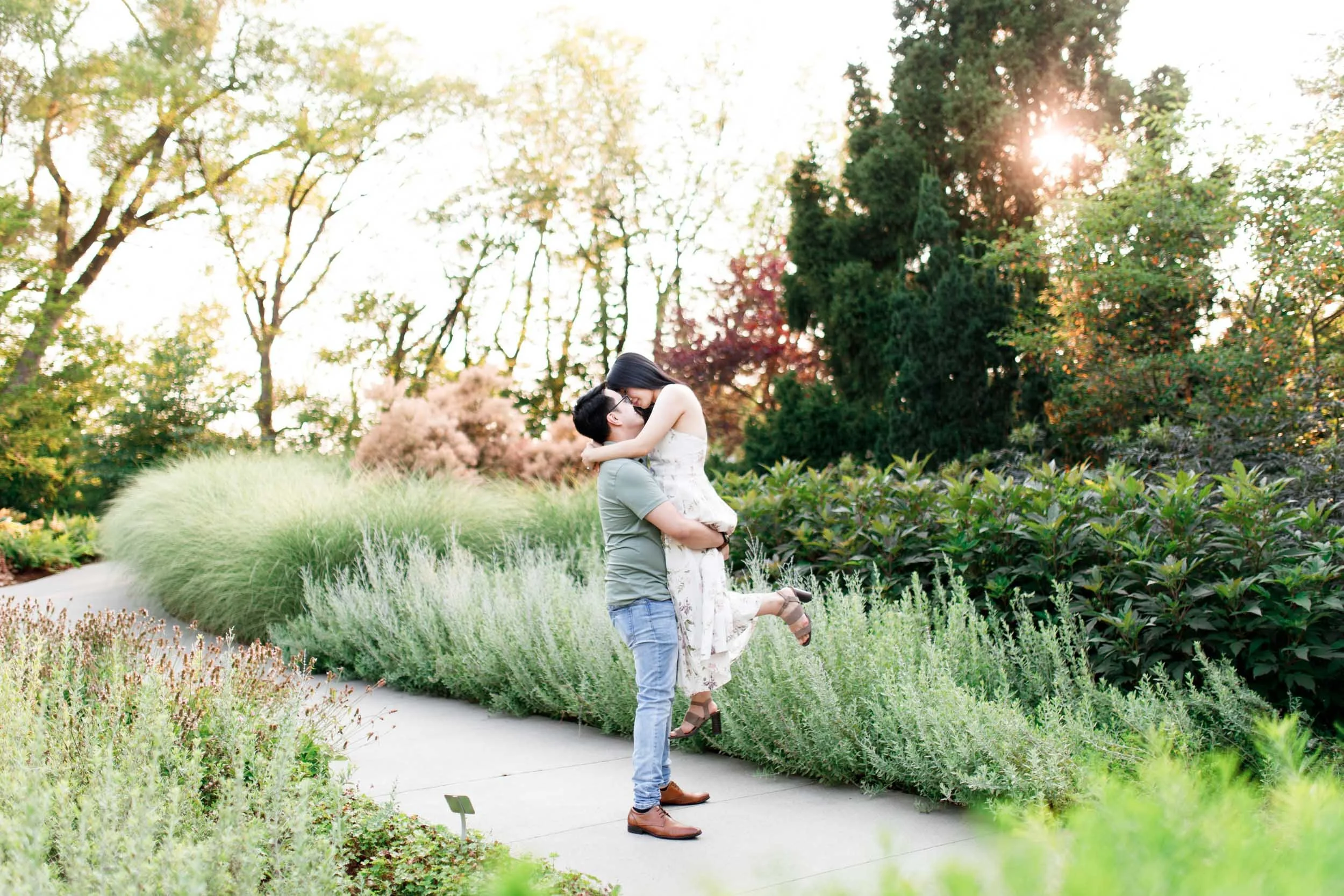 Couple lifting and kissing during their engagement session at the RBG Rock Gardens in Burlington, Ontario