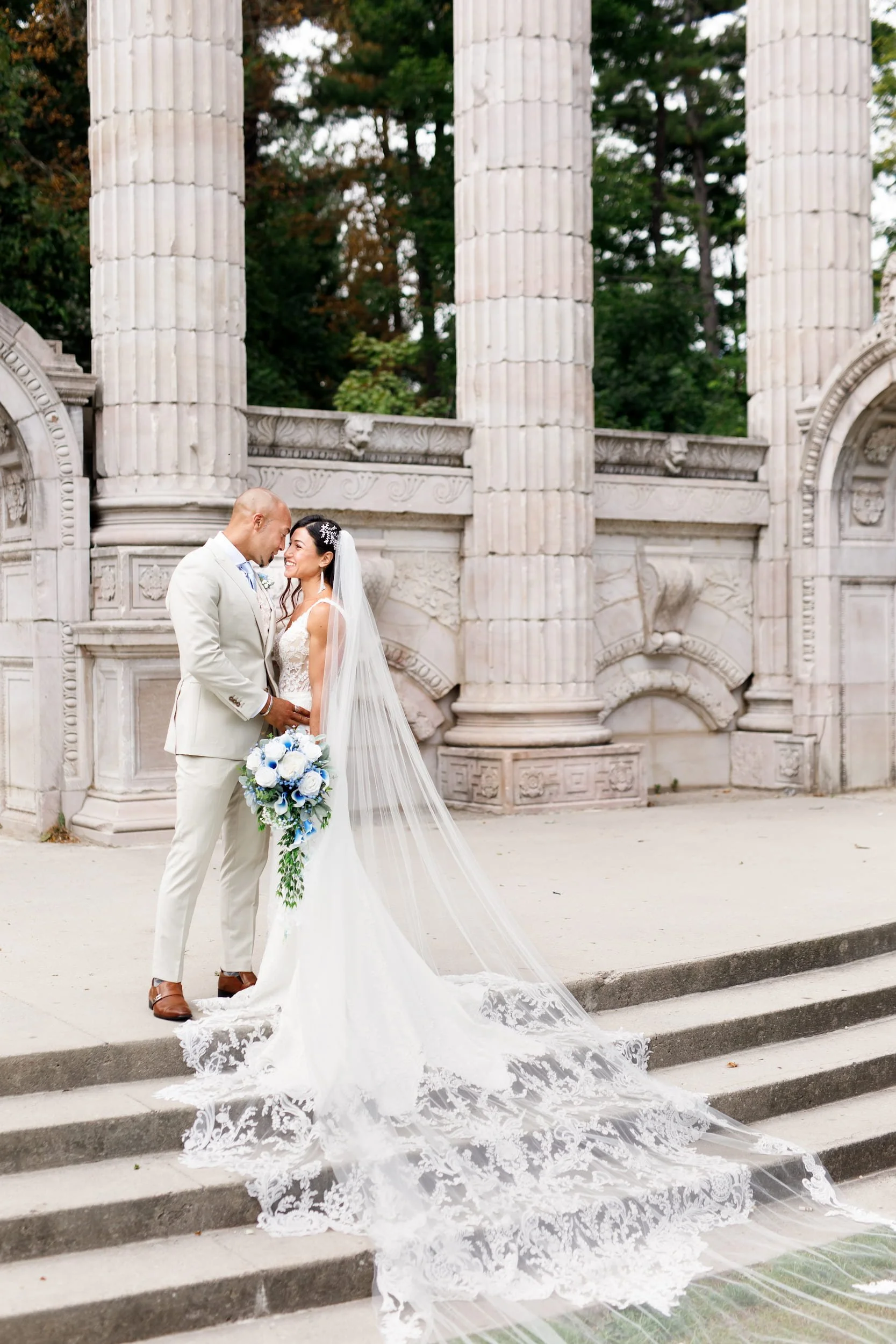 Bride and groom portrait beneath classical columns at Guild Inn Estate