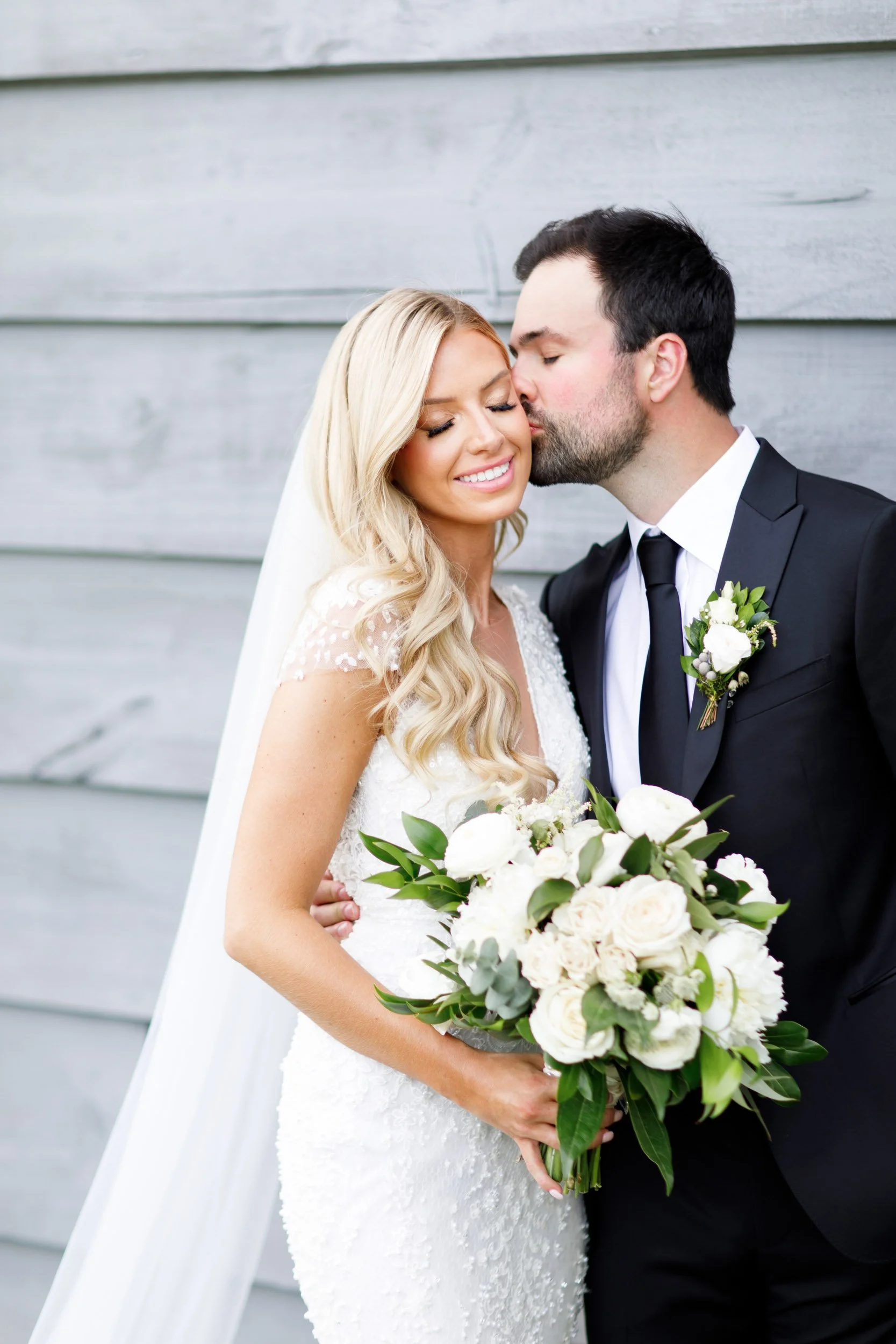 Groom kissing bride’s cheek during romantic wedding portraits at Roseville Estate in Cambridge, Southern Ontario