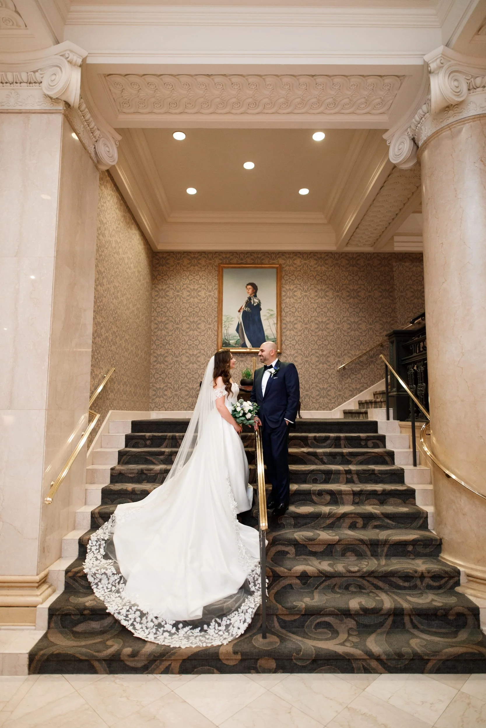 Bride and groom on grand staircase during Omni King Edward Hotel Toronto wedding portrait