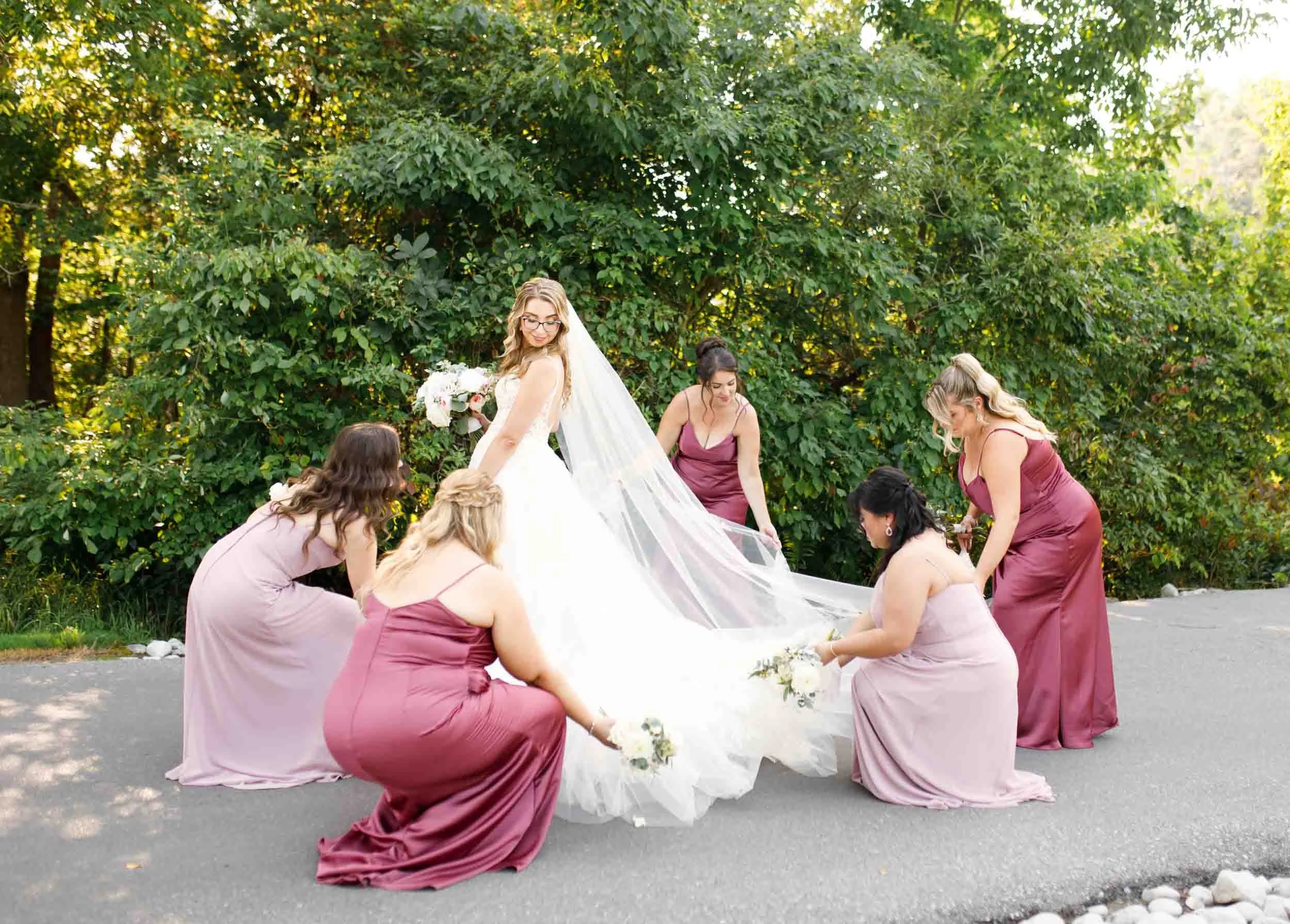 Bridesmaids adjusting train outdoors at Whistle Bear Golf Club in Cambridge, Ontario
