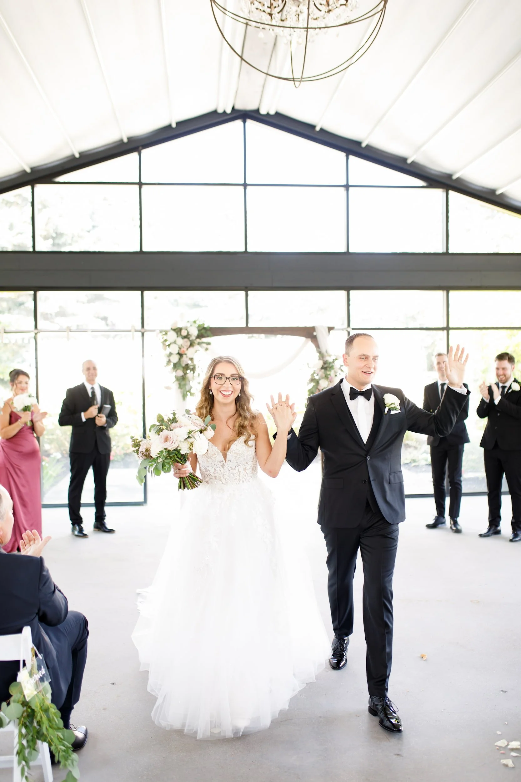 Newlyweds celebrating recessional inside ceremony space at Whistle Bear Golf Club wedding in Cambridge, Ontario
