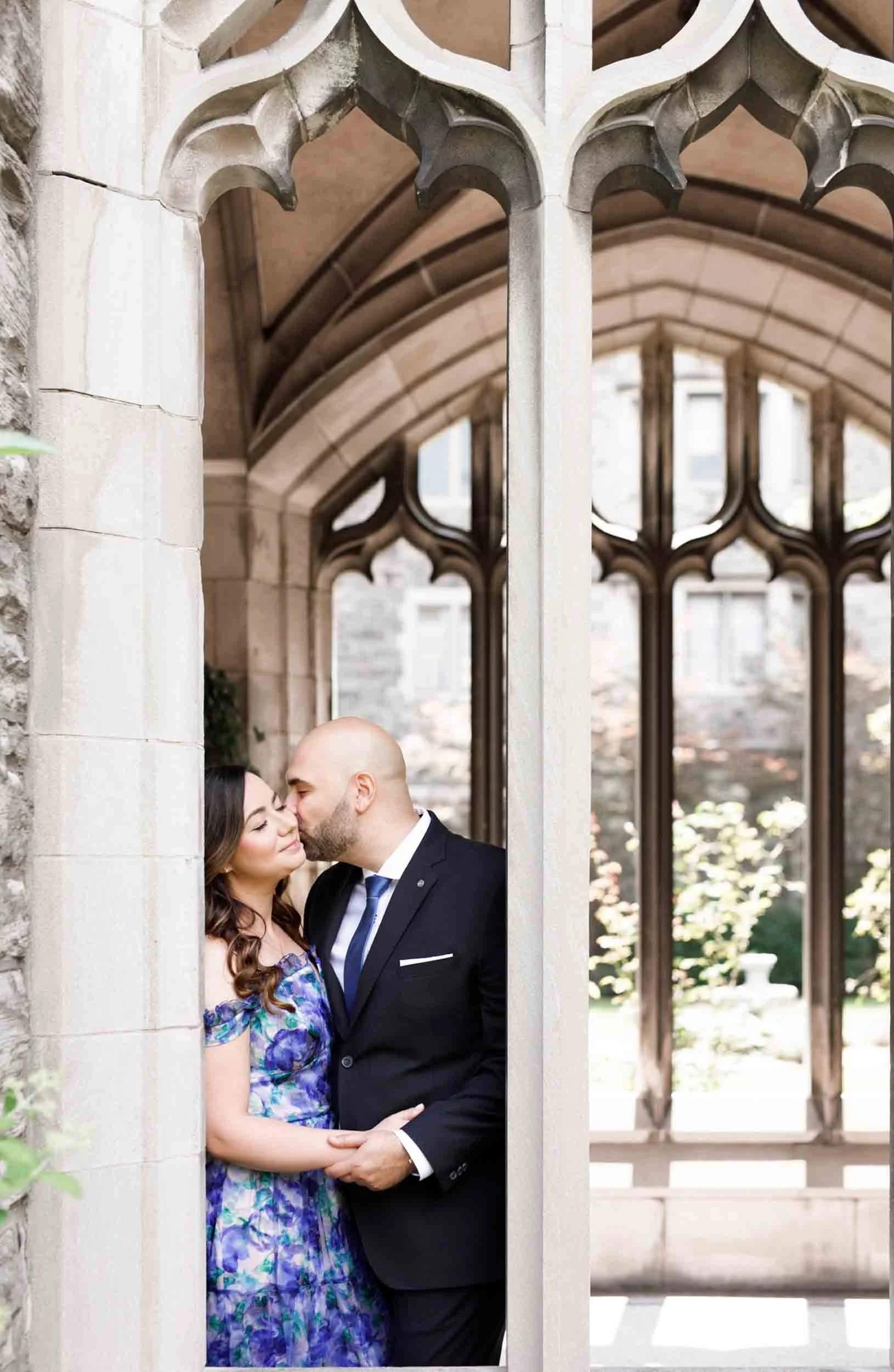 Romantic kiss framed by Gothic archway at Knox College, University of Toronto in Toronto, Ontario