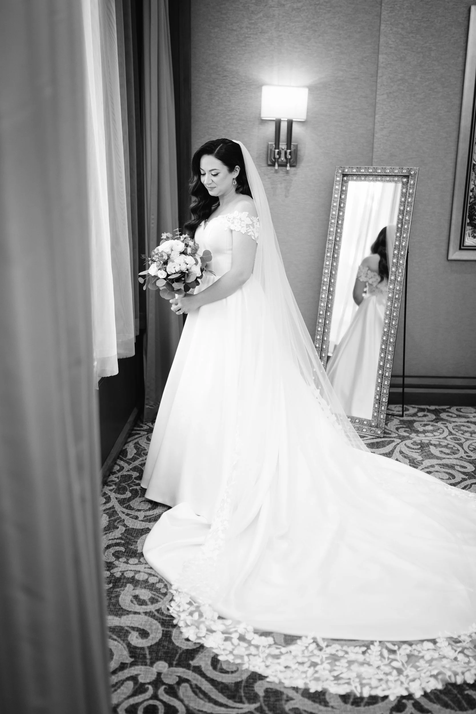 Black and white portrait of bride in wedding dress holding bouquet in hallway portrait at Omni King Edward Hotel Toronto