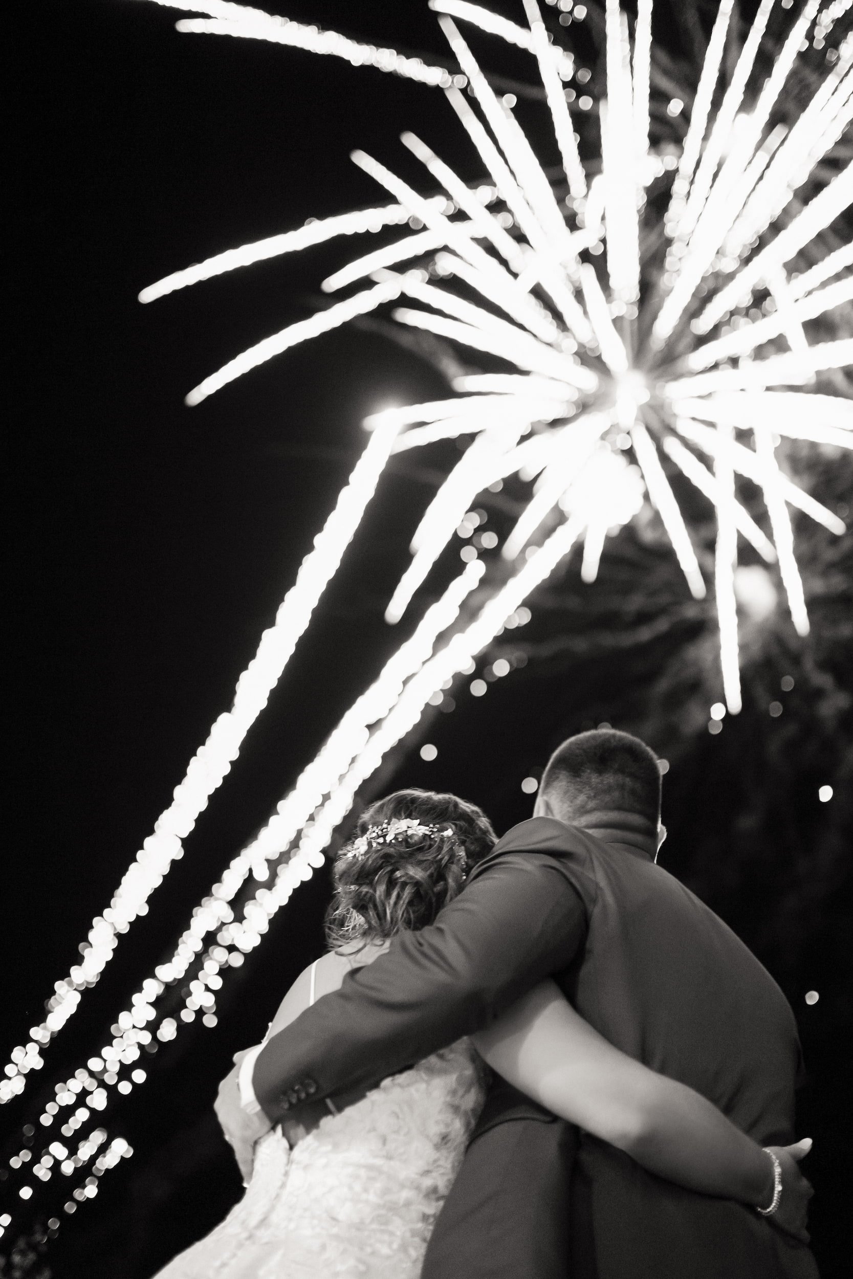 Black and White shot behind Newlyweds watching fireworks display outside The Manor Event Venue in King, Ontario