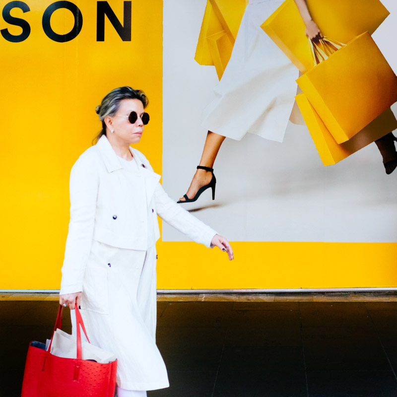 A woman walks past a billboard outside a large department store in the Bourke Street Mall in Melbourne