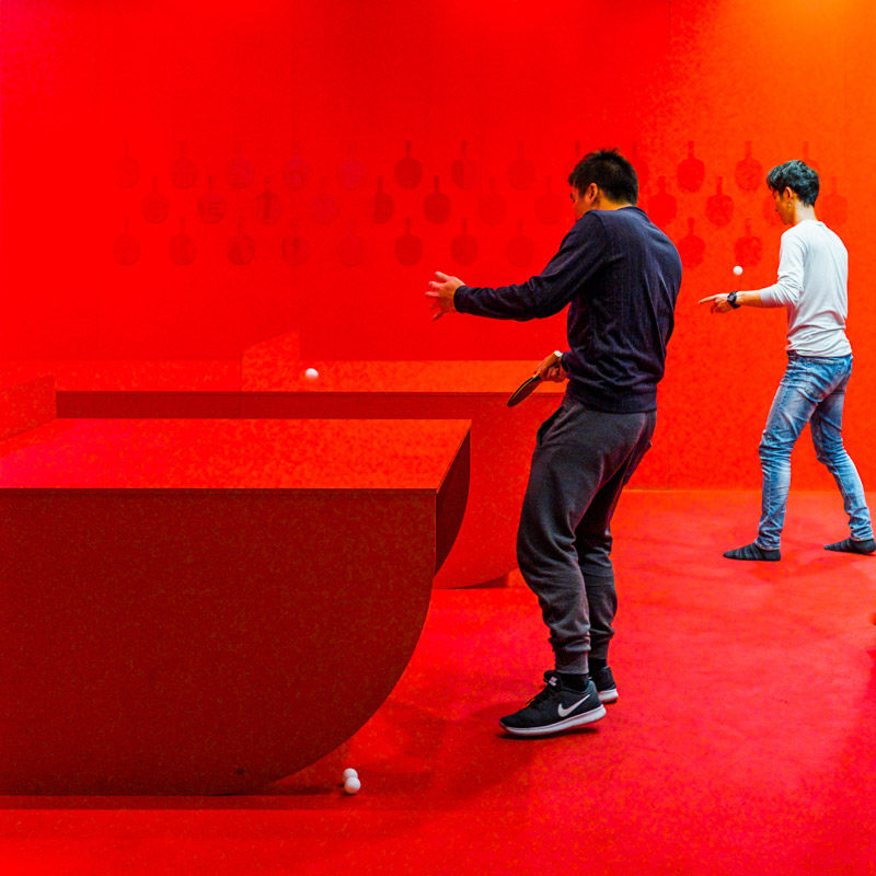 Students playing table tennis at a communal Table tennis room in a Melbourne food court.