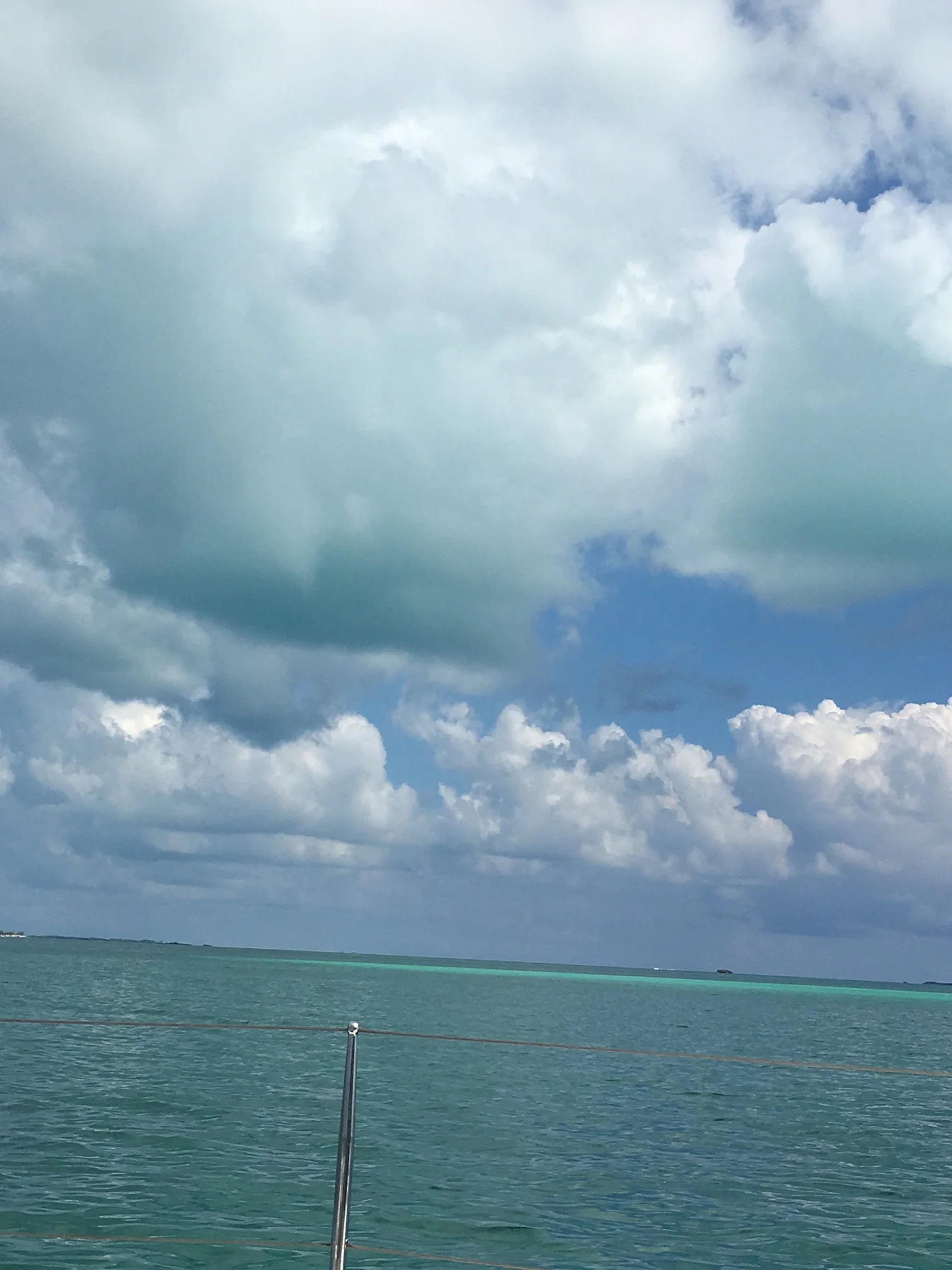 Blue-green water reflecting on clouds.