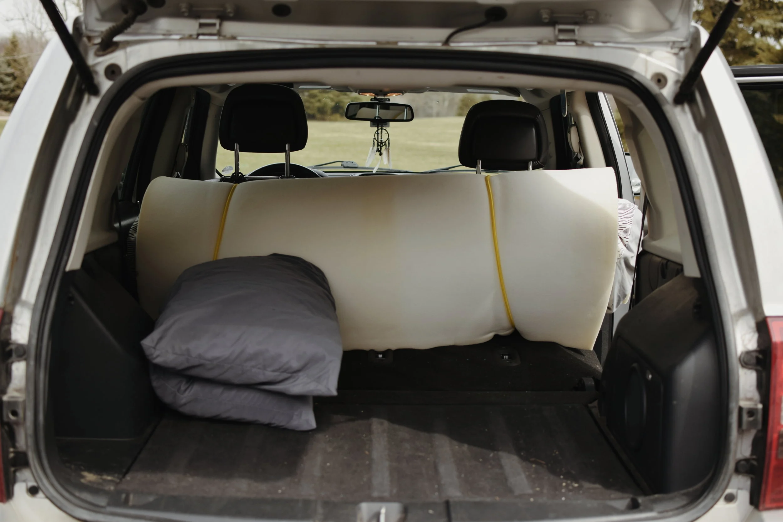 With all of my gear cleared out and moved to the front seats, I was left with a perfectly sized sleeping space for two people in the trunk of my car. I kept my bed rolled up like this for storage purposes, and to make it easy to roll out in just a few seconds. 