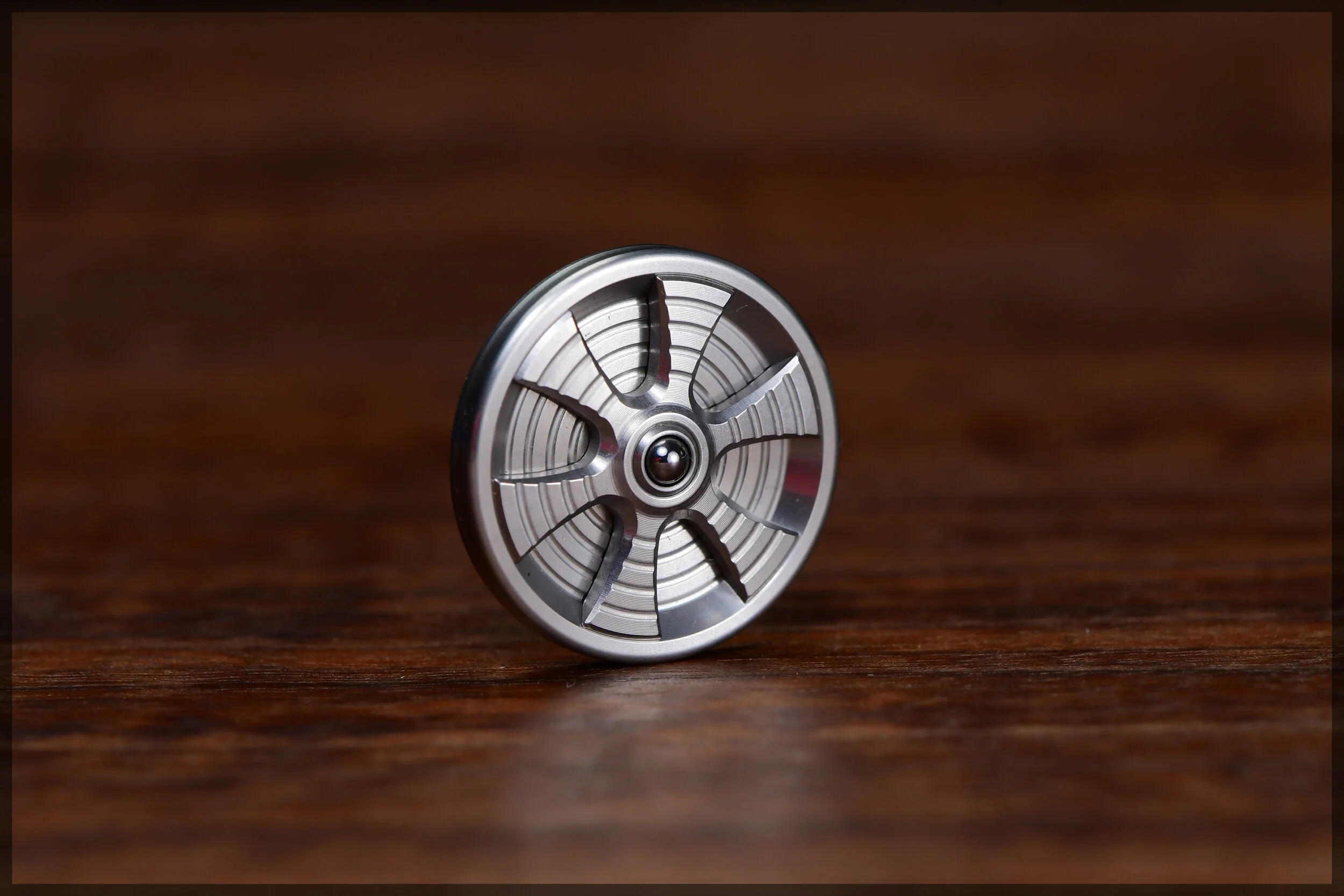 stainless steel Gambit coin with a stainless steel spoked inlay and bearing ball