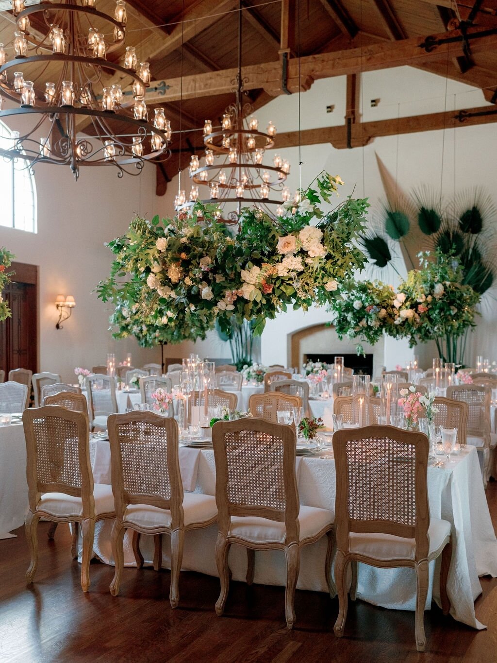 We did a hanging installation at each table, which left room for the beautiful place settings and lots of candles. While there were minimal flowers on the tables, it still made for a big floral impact. 

Photography: @aliciaminkphoto
Planning and Des