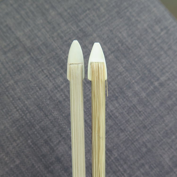 The bow hair on the left appears white in colour and has rosin, the bow on the right appears yellow and needs rosin. 