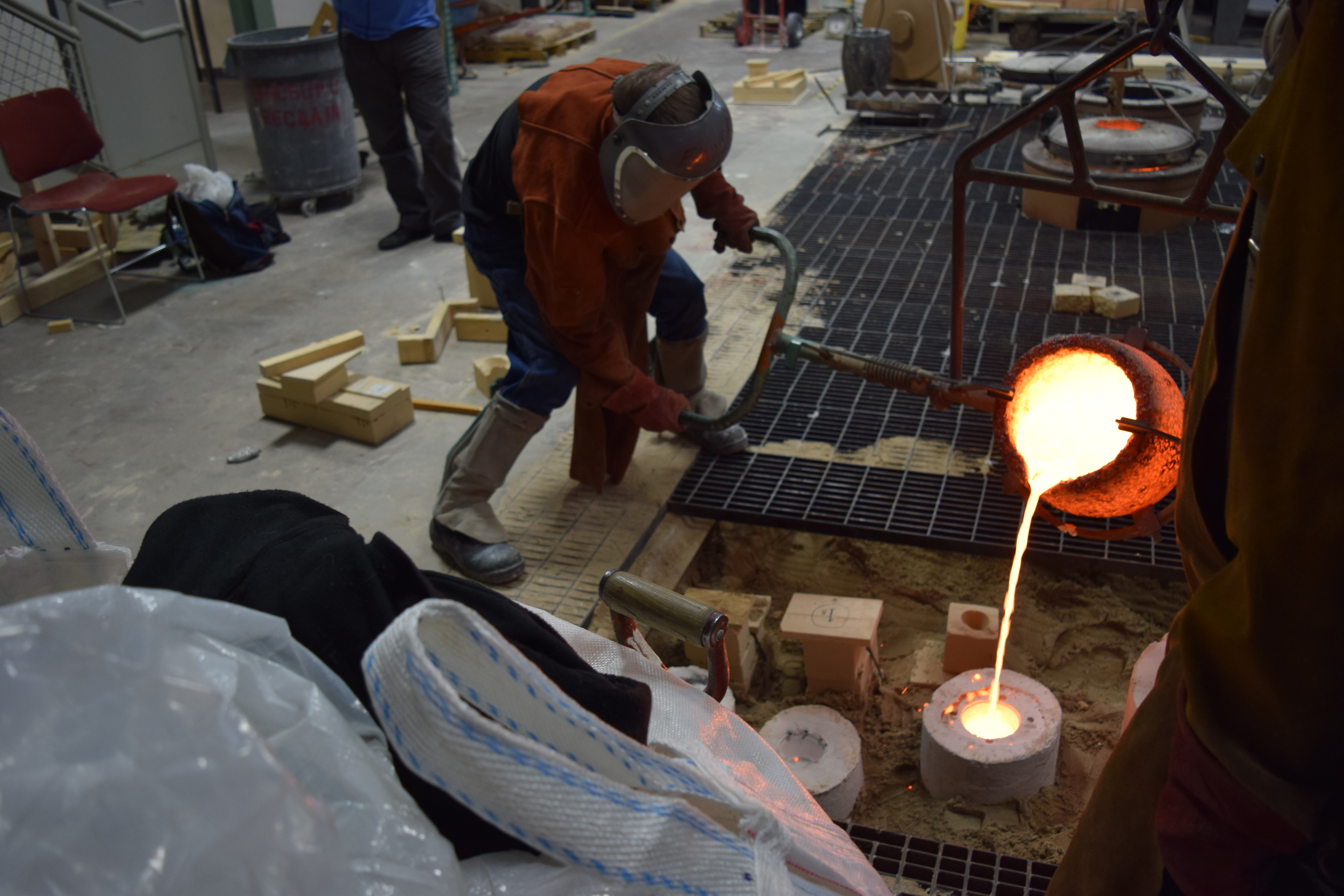  At the foundry, pouring the bronze into the plates' investment mold. 