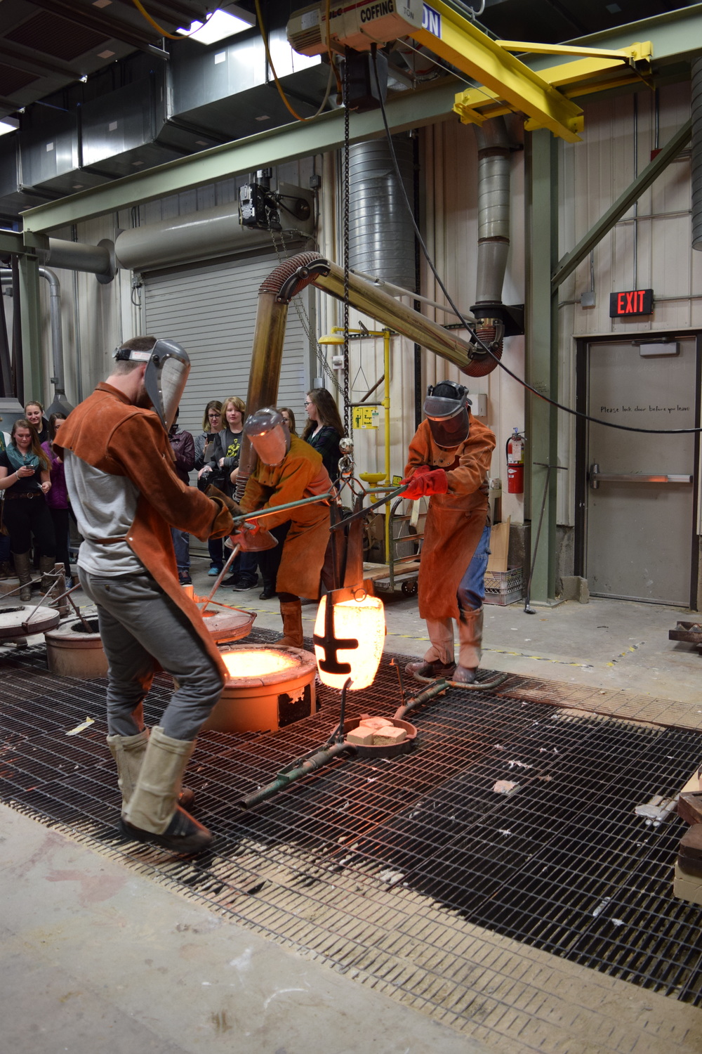  Bringing the bronze crucible out of the forge. A group from a local high school was observing.   