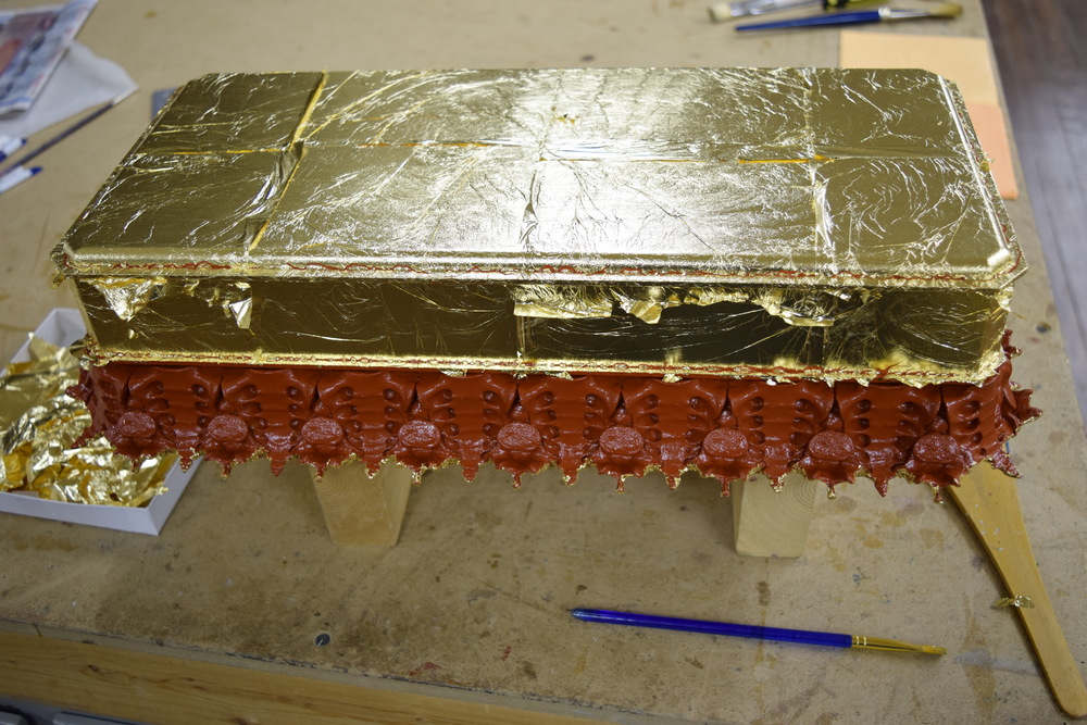  Applying the gold leaf to the top of the base. 