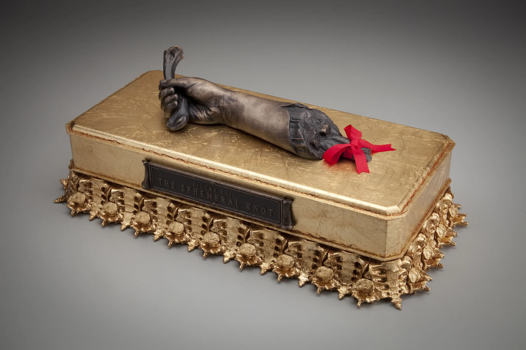Figure Seventeen.- The Ephemeral Knot 2015-2016. 7”h x 19.5”w x 10.5”d. Bronze, Wood, Resin, Acrylic, Gold leaf, Silk, Hardware.