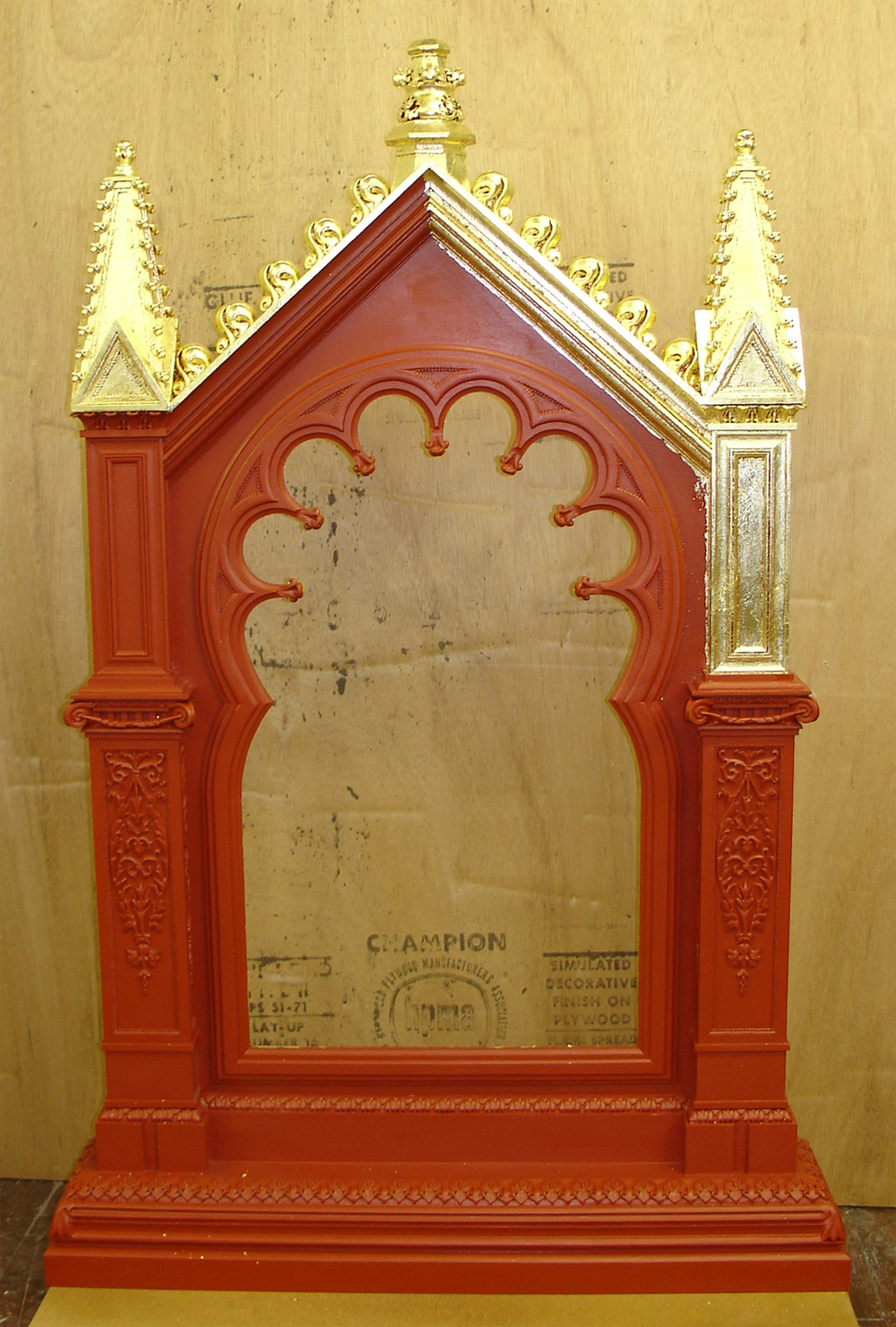  The frame with all of the ornament on, as well as the red bole, starting to be gold leaf gilded. 