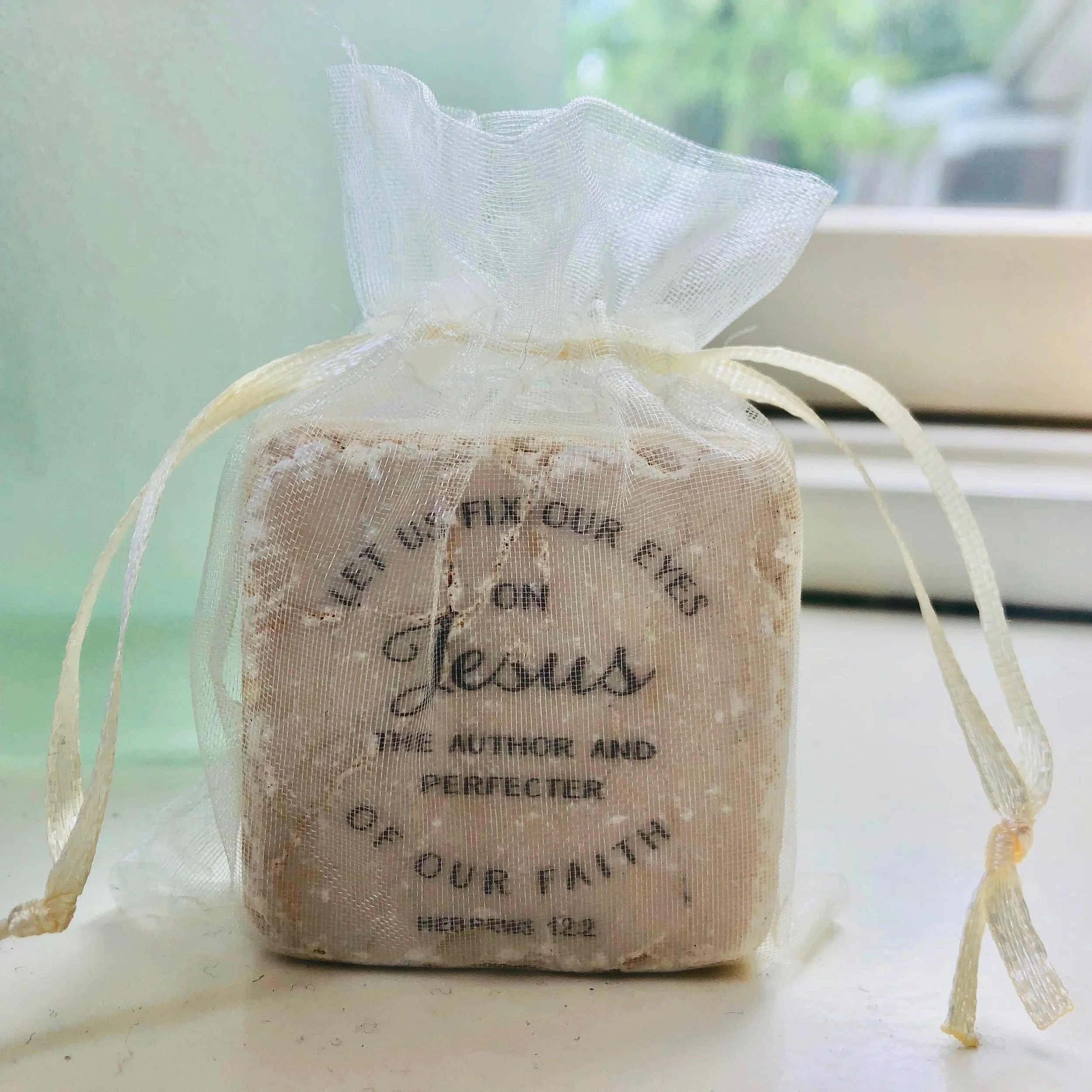 Each scripture stone is wrapped in an organza bag.
