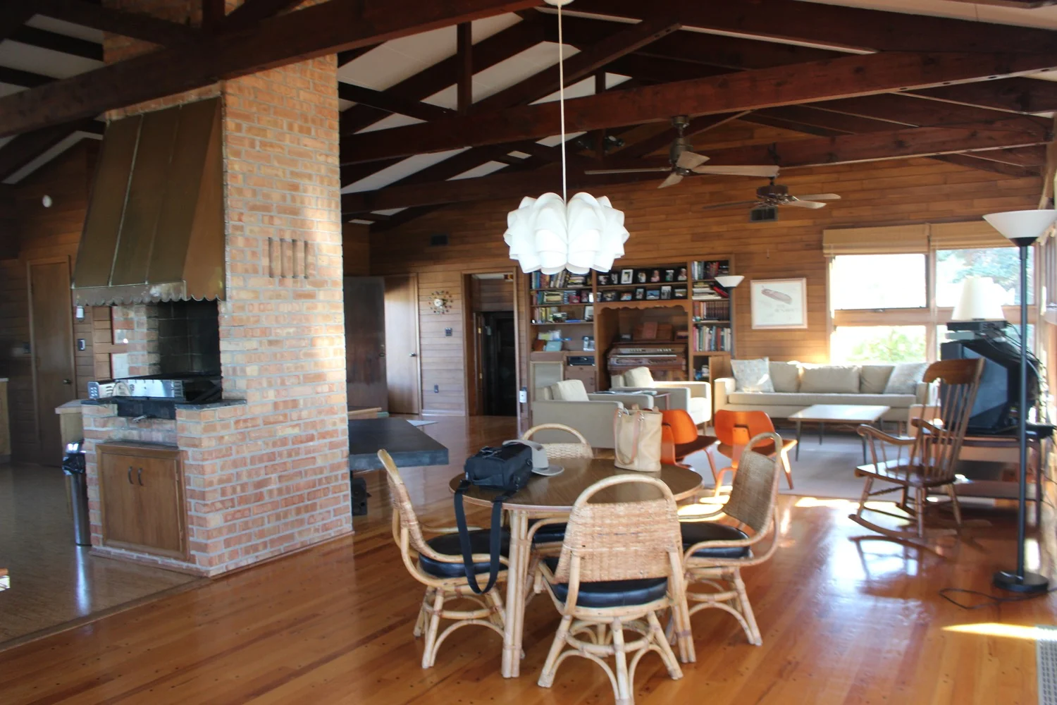 One of the striking features is the massive angled brick fireplace wall with staggered vents and a built-in rotisserie grill.
