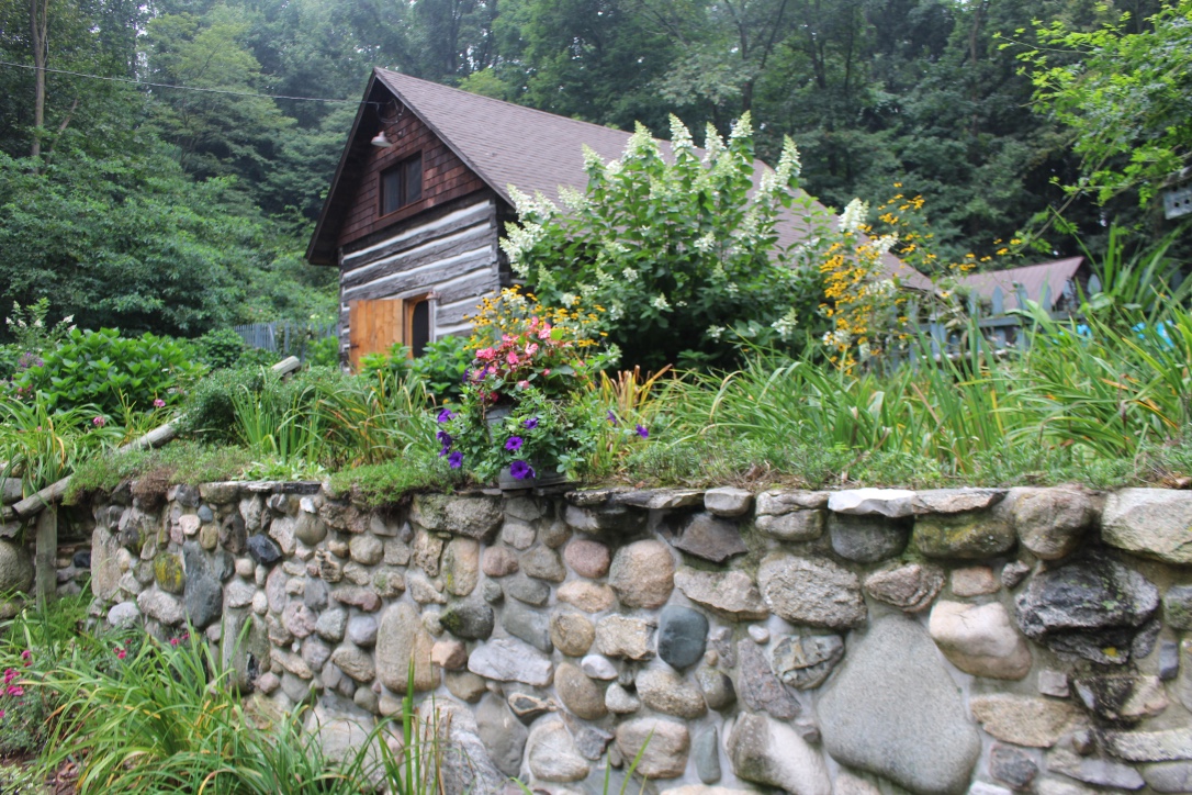 View of the cabin and screen door behind authentic stone wall 