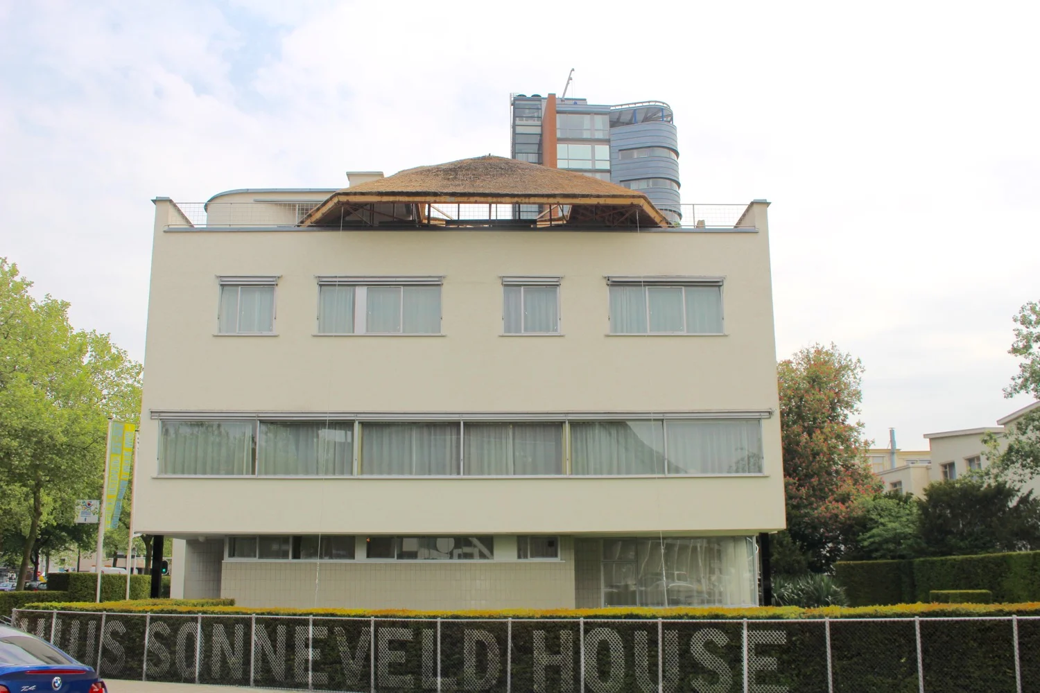 FRONT EXTERIOR WITH BANKS OF WINDOWS AND UNIQUE ROOFTOP DECK STRUCTURE