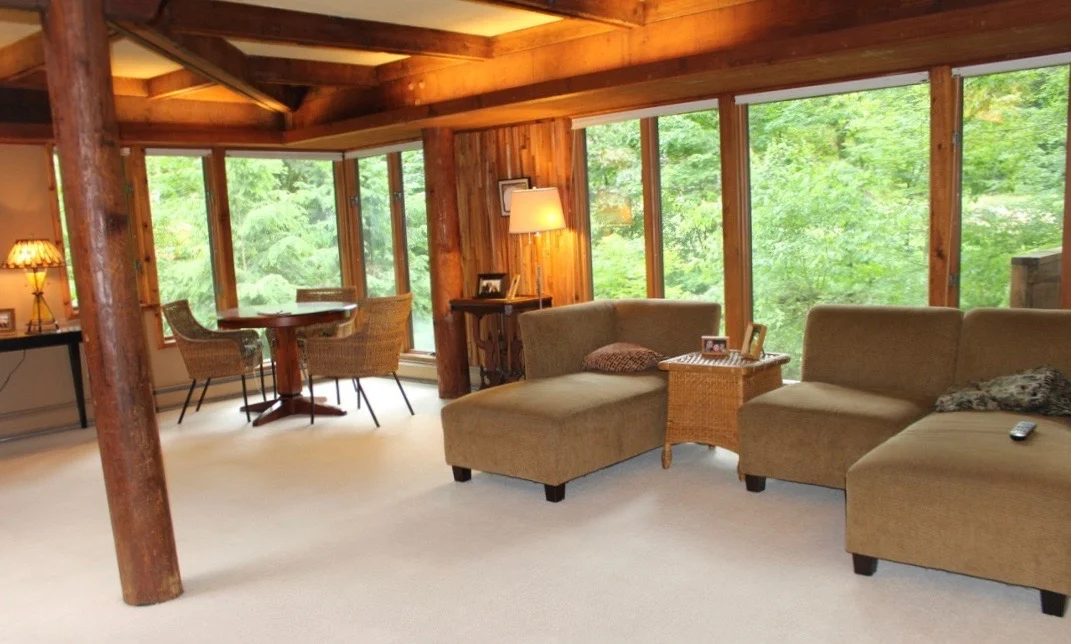GLASS WINDOW WALLS WITH DECORATIVE WOOD PANELING OF ROUGH-SAWN CEDAR.