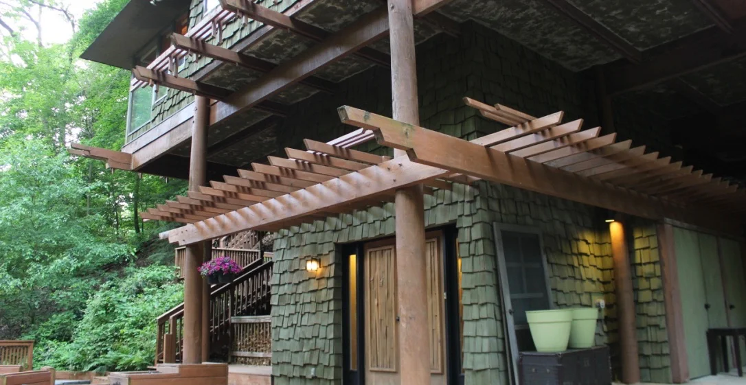 The green-shingled exterior of the gloriously sculptural TreeTops. The beams make a perfect place to hang flowering planters in the summer months.