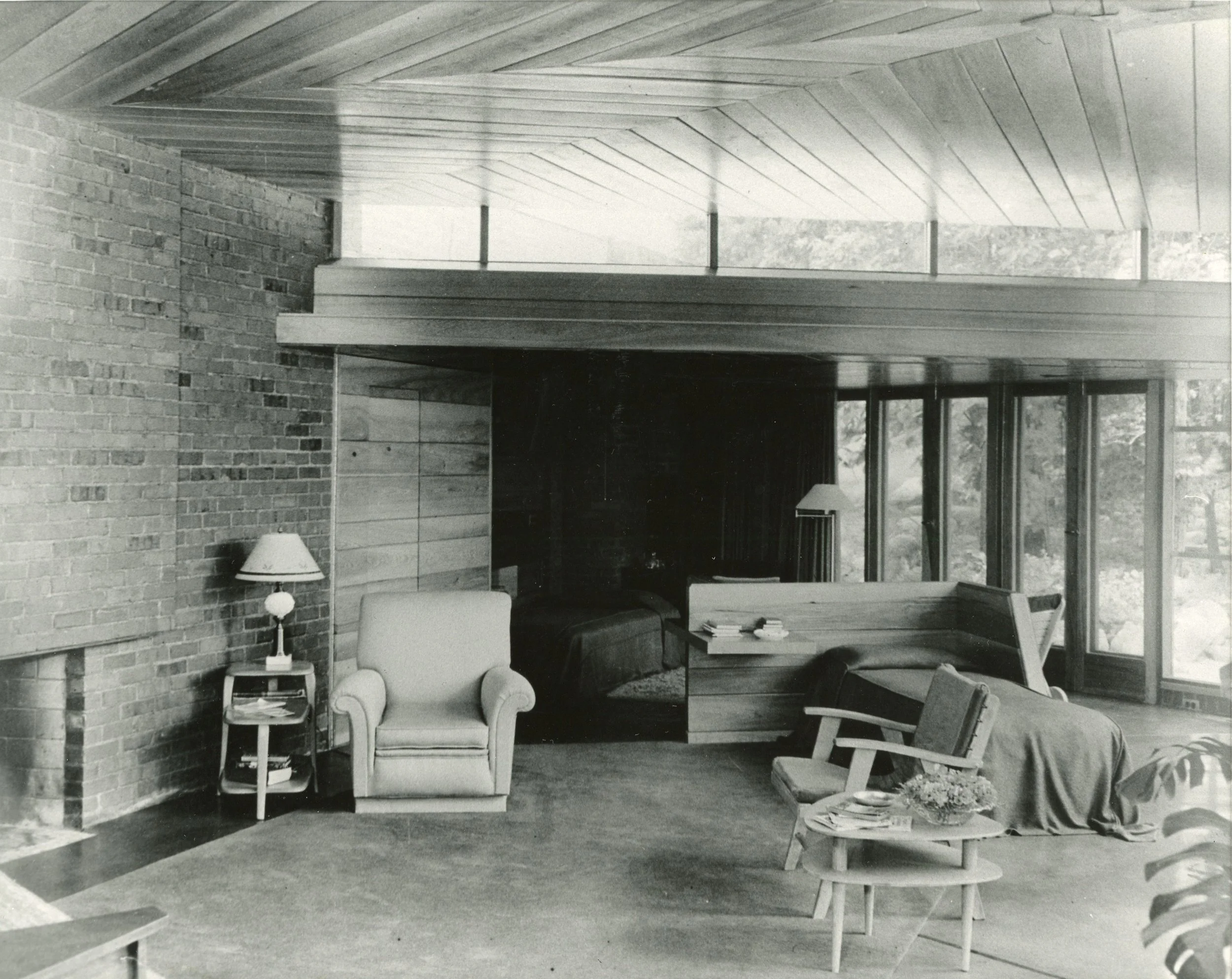 Behind the fireplace grouping in the living room is the half-wall partition separating main area from bedroom.