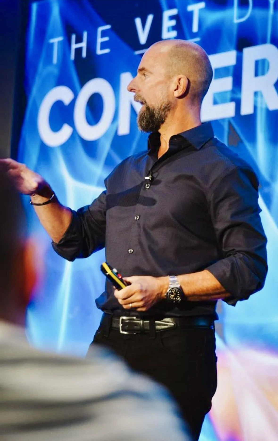 Dr. Ernie Ward, DVM, speaking on stage during a veterinary presentation.