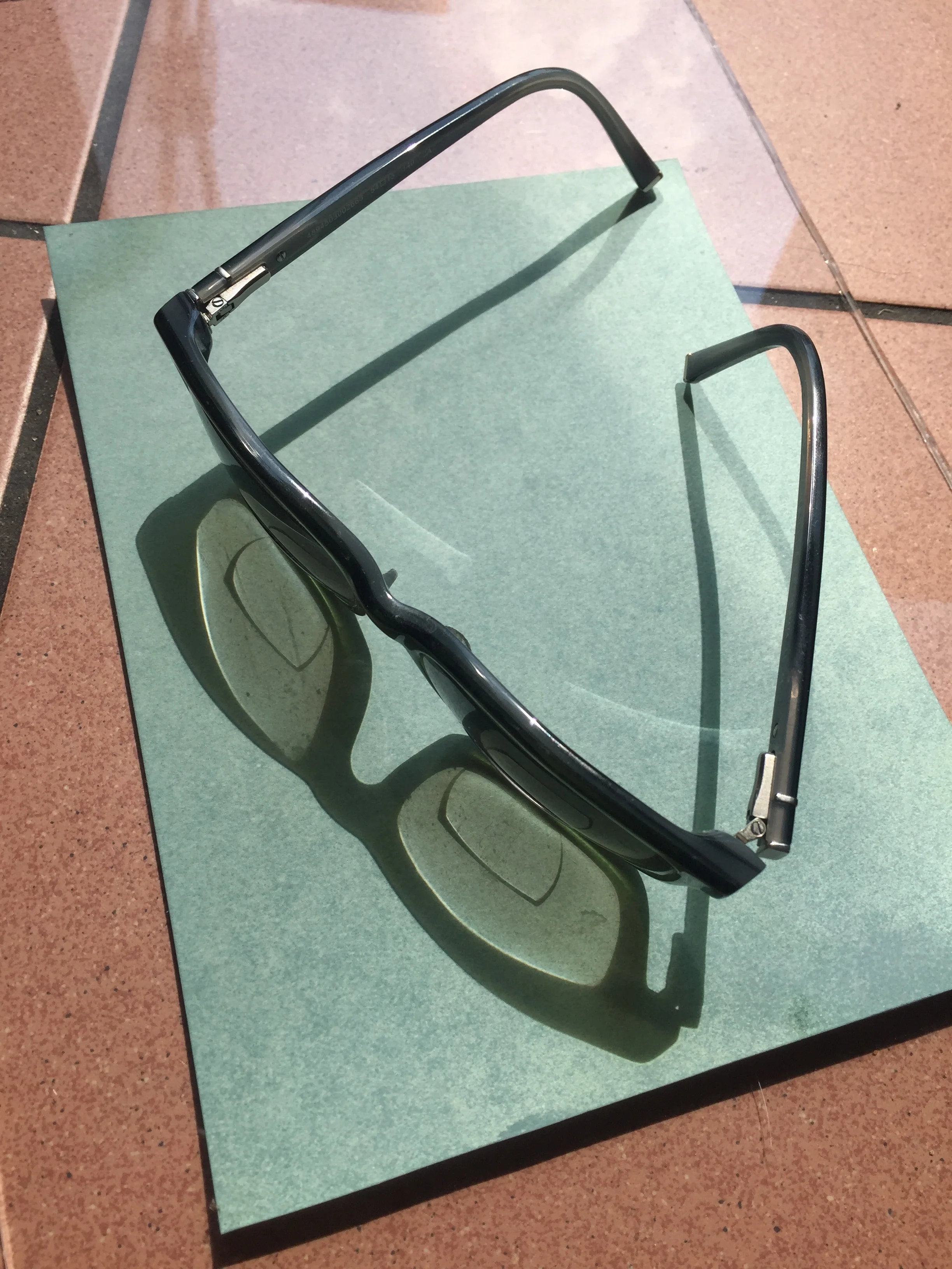 In the patch of sunlight in an open doorway, a cyanotype is in process. Glasses belonging to one of the residents at Bluebell Lodge cast a shadow which blocks the light whilst the rest of the photosensitive paper reacts and becomes gradually paler.