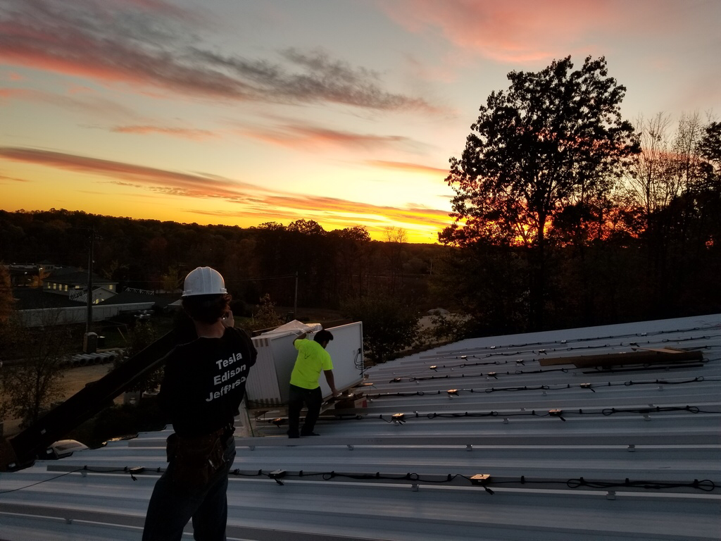 Joel Walsman and Max Hanania finish up mounting Ironridge rails on one of the fire stations in Bloomington, Indiana. 