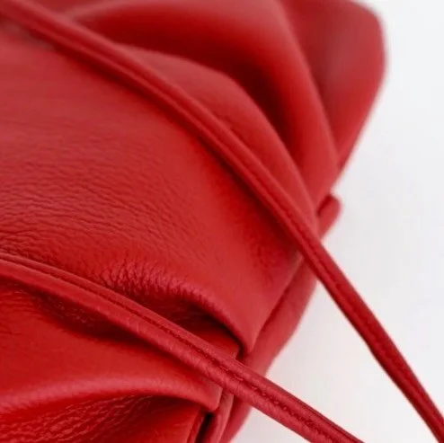 Pleated detailing for a touch of elegance. A slim, attached strap that can be knotted for versatile wear&mdash;whether on your shoulder or crossbody. As comfortable in the palm of your hand or carried as a clutch.  #jerseygirl &hearts;️