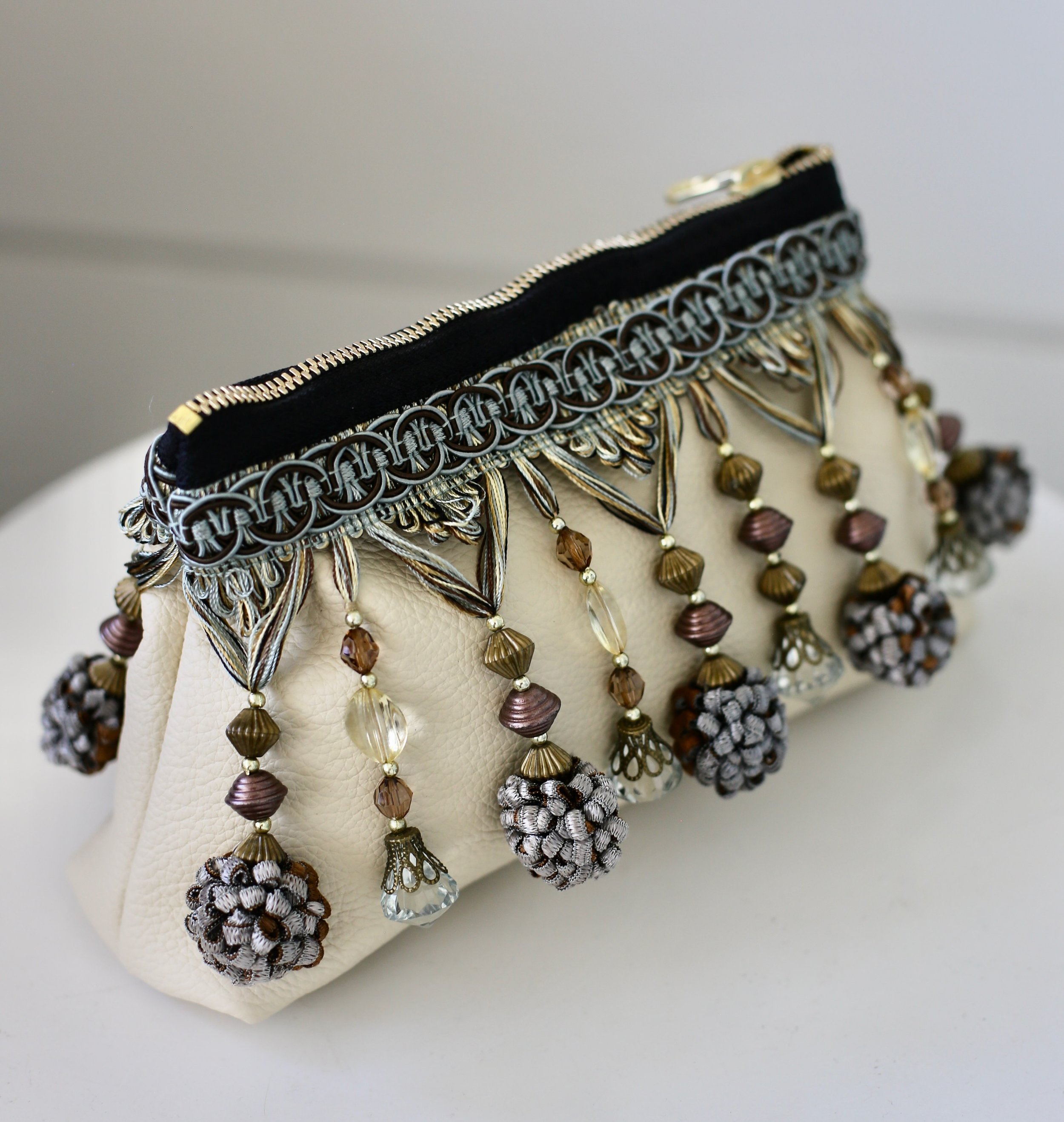 Inspired by my work as an interior designer, the Limited Run Tassel Clutch is a perfect example of how creativity flows from one passion to another. Crafted from decorative trim in blue and amber tones, this piece brings the richness of interior deta
