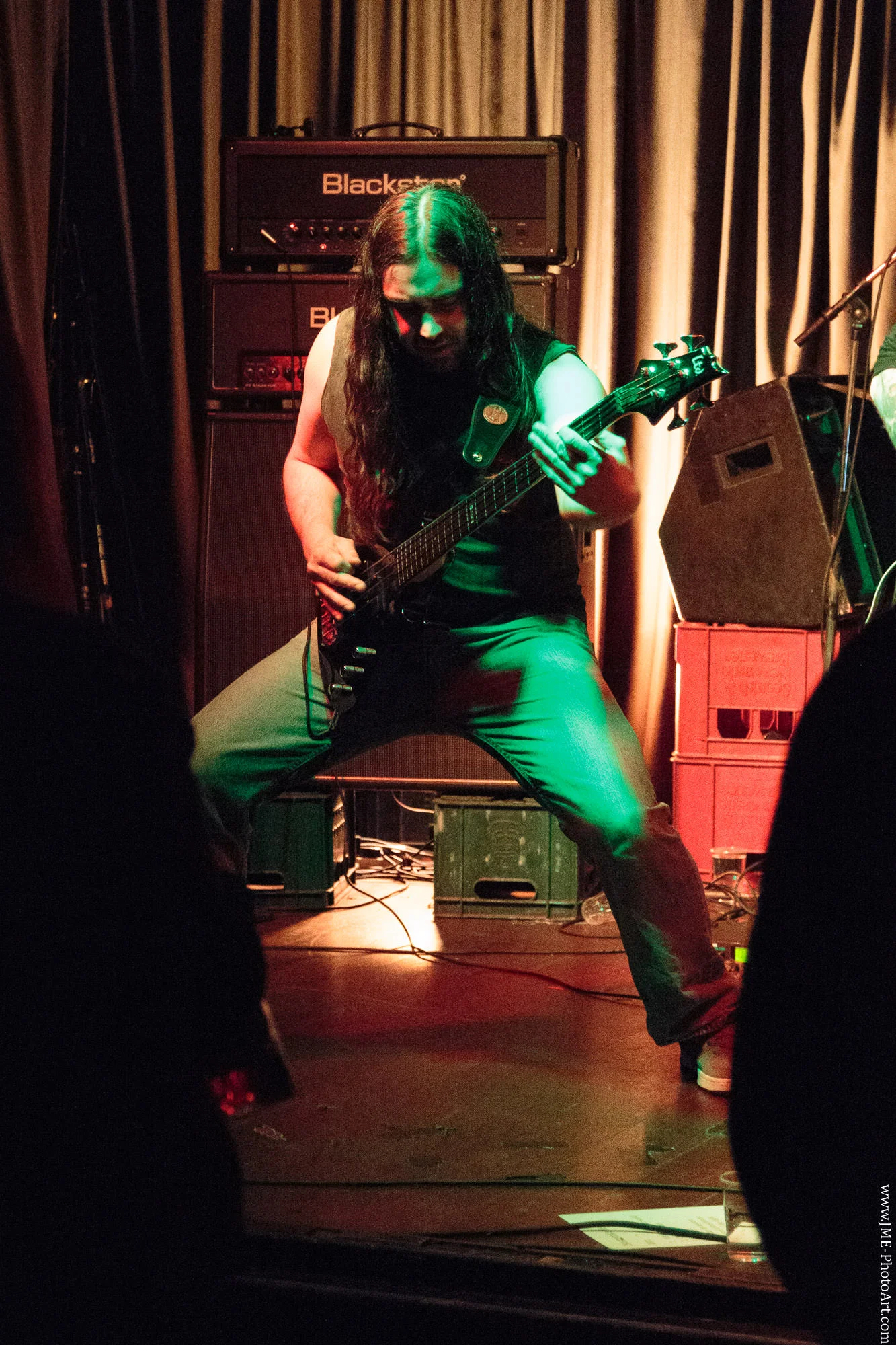 Legs apart with the guitar thrust outwards