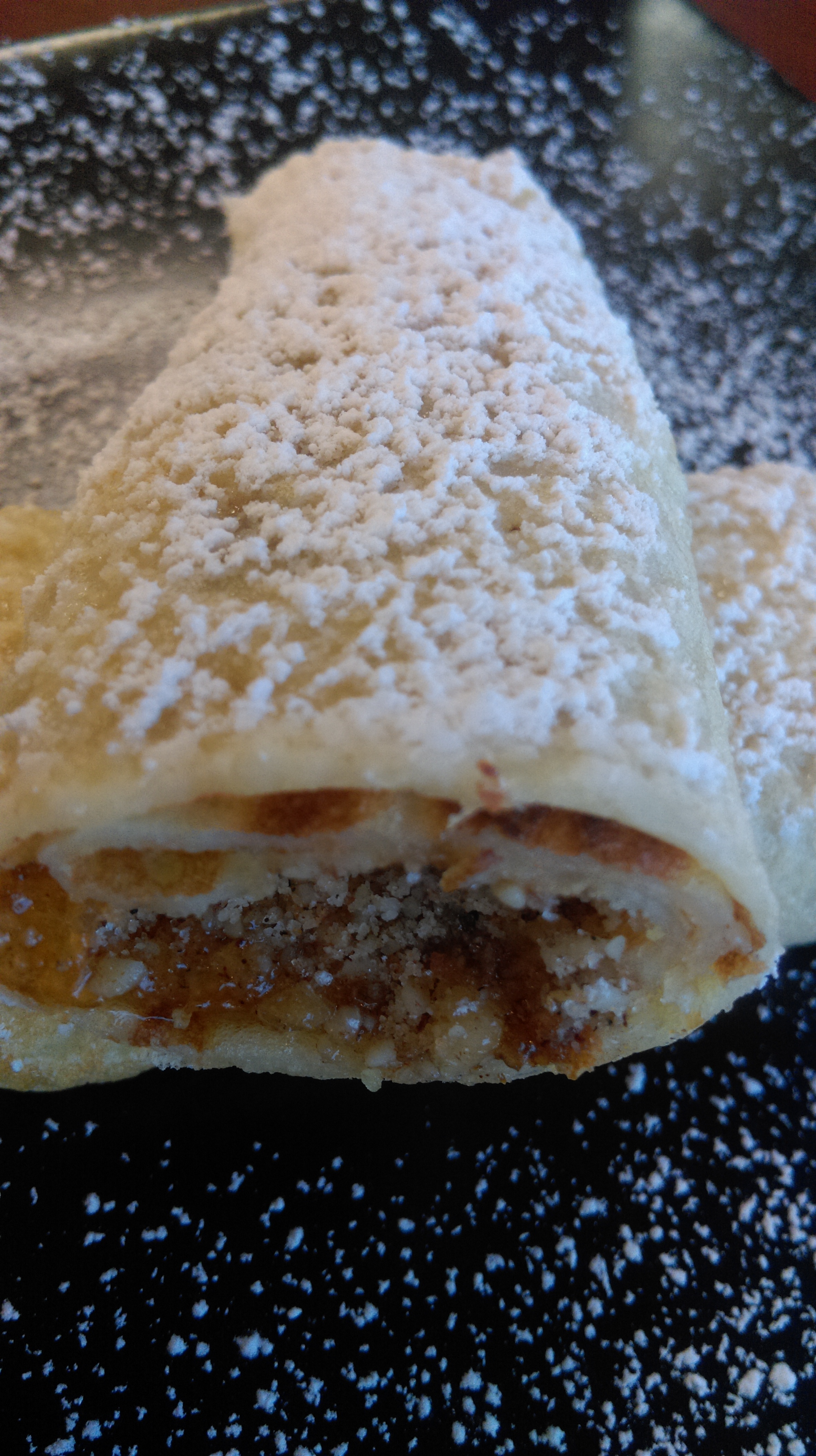Hungarian crepe (Palacsinta) with apricot and nut filling, dusted with powdered sugar.