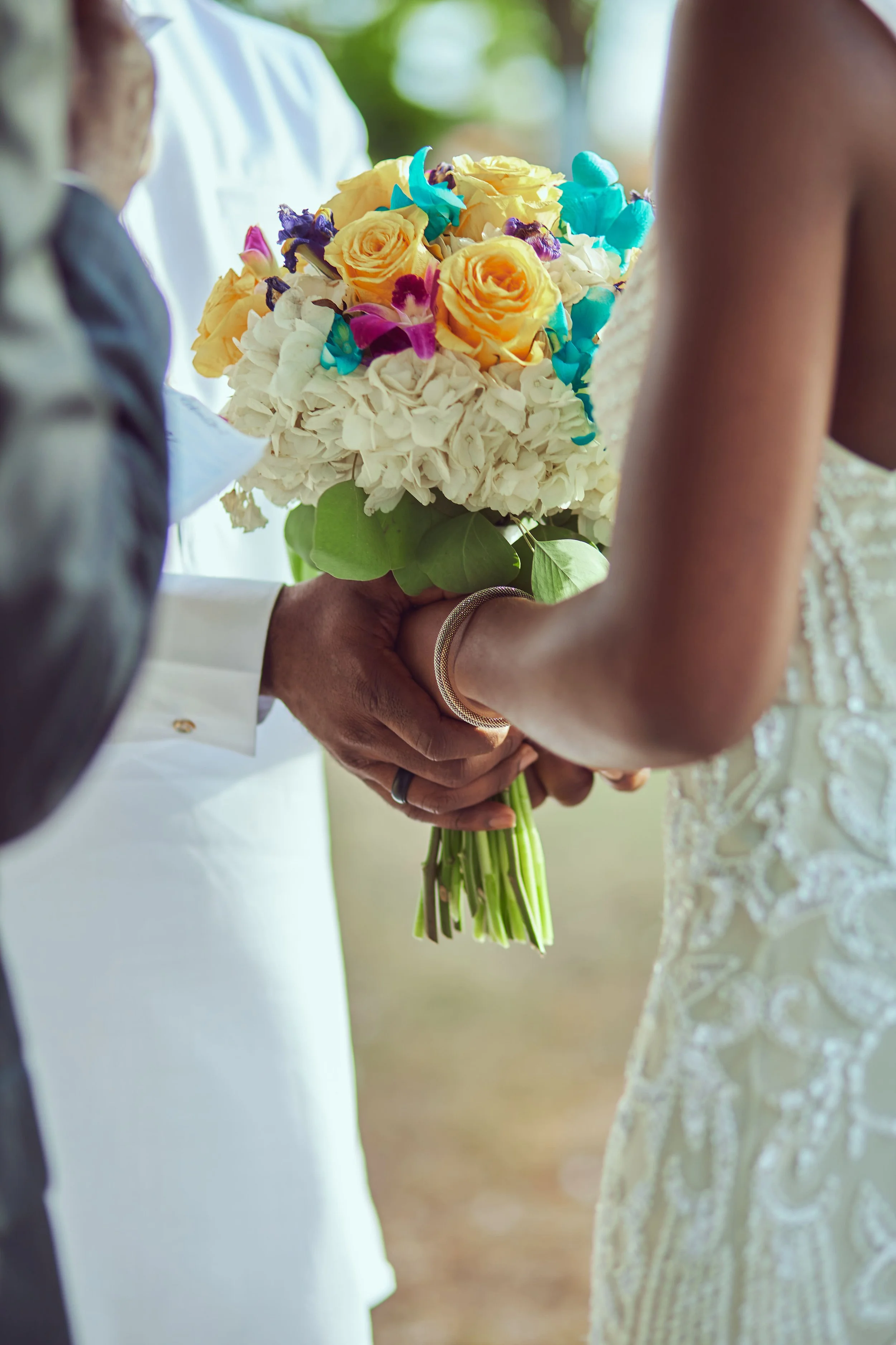 A man and a woman holding a bouquet of flowers during a wedding ceremony.