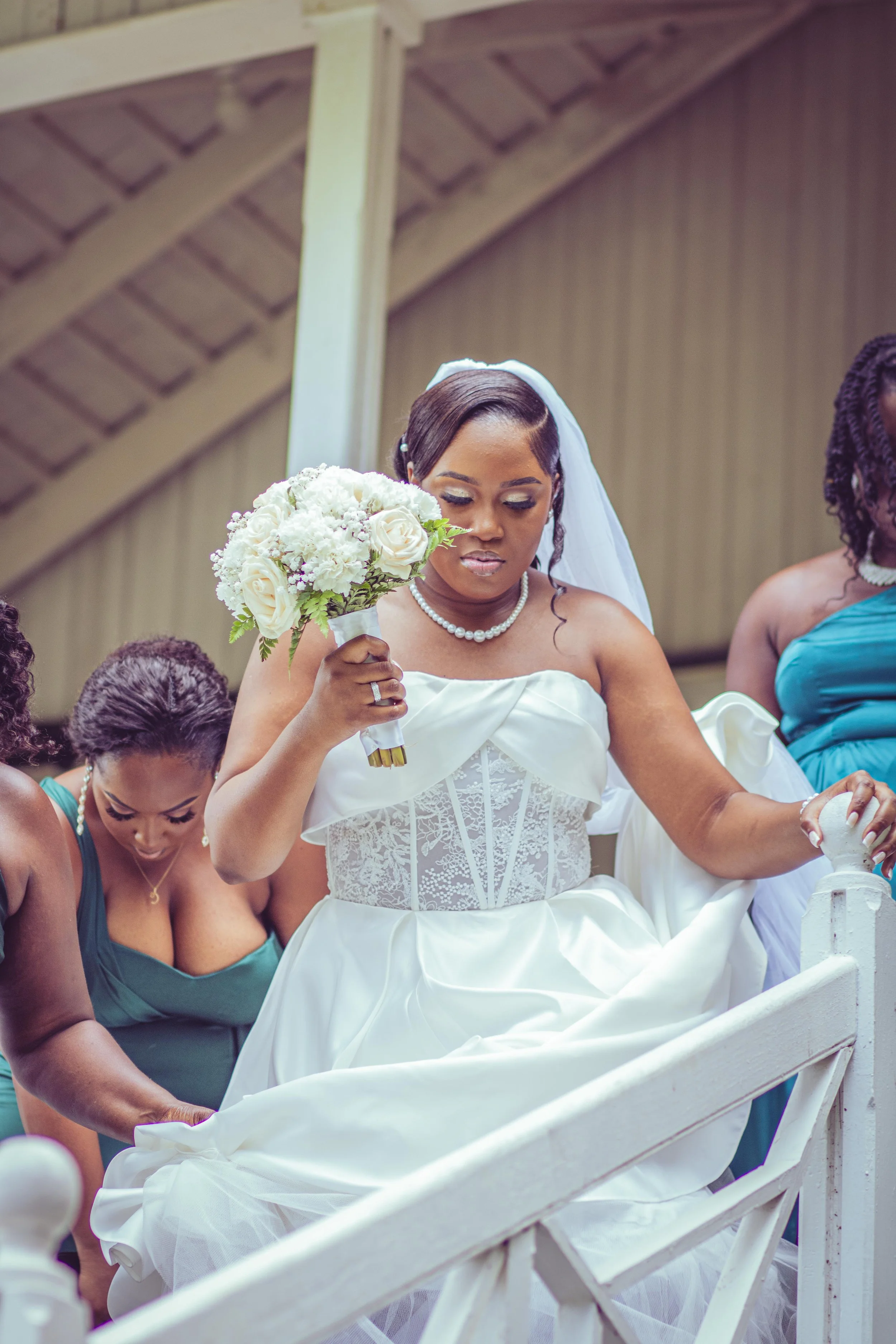 Bride in a white wedding gown holding a bouquet of white roses and hydrangeas during a wedding ceremony.
