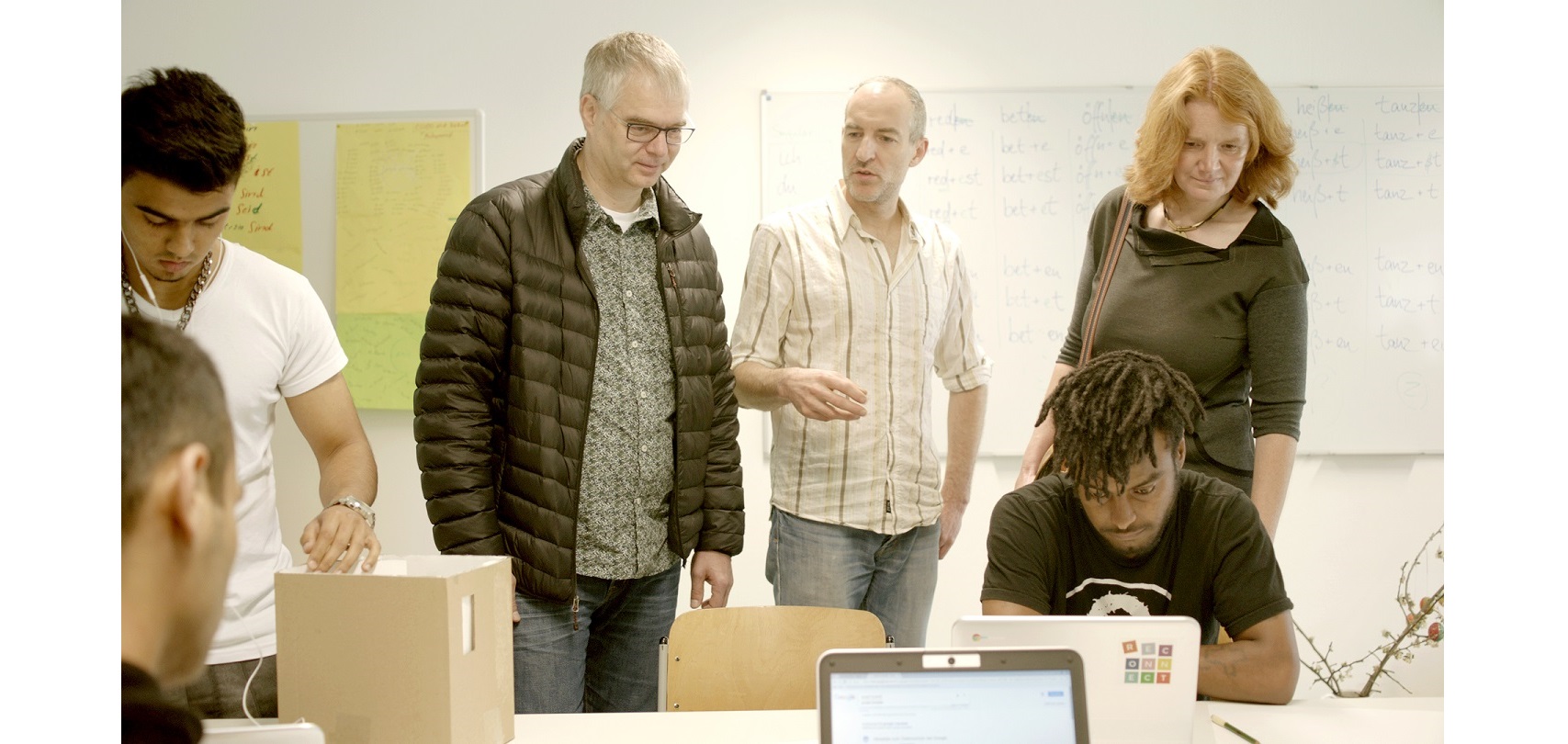 Wieland Holfelder, Google Germany (standing, 2nd left) and Sybille Fleischmann, NetHope - Project Reconnect, are visiting Markus Hoffmann (center) in his preparatory class at the public trade school in Dachau.