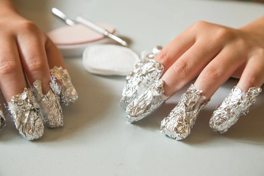 Removal is done by soaking a cotton ball in acetone, placing it on top of the nail, and then covering in tin foil for about 30 minutes. 