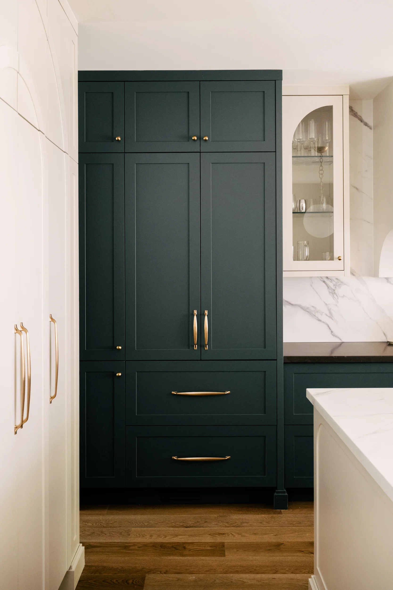 A closed, dark muted turquoise cabinet with gold hardware