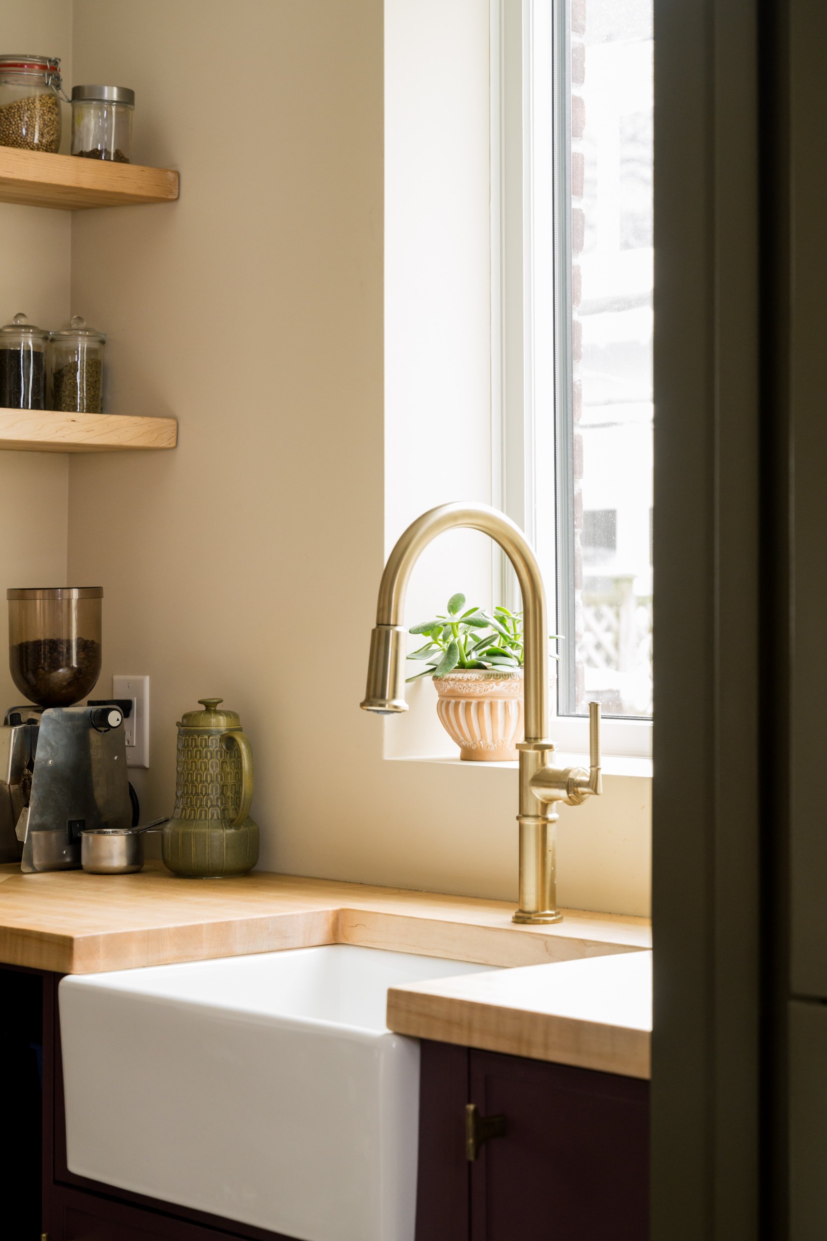 Small kitchen sink with gold faucet in a pantry