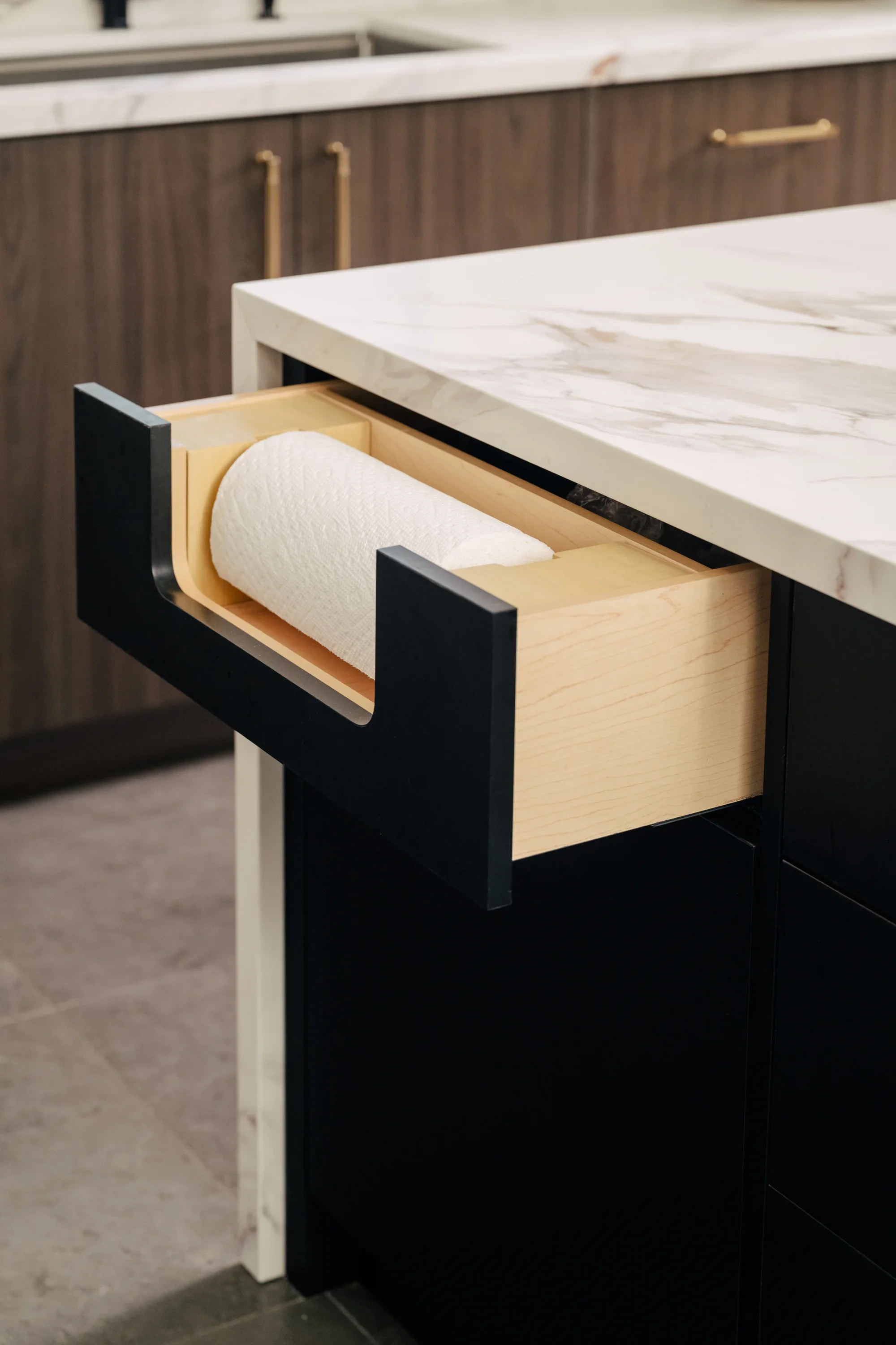 A custom paper towel drawer is built into the kitchen island for easy access.