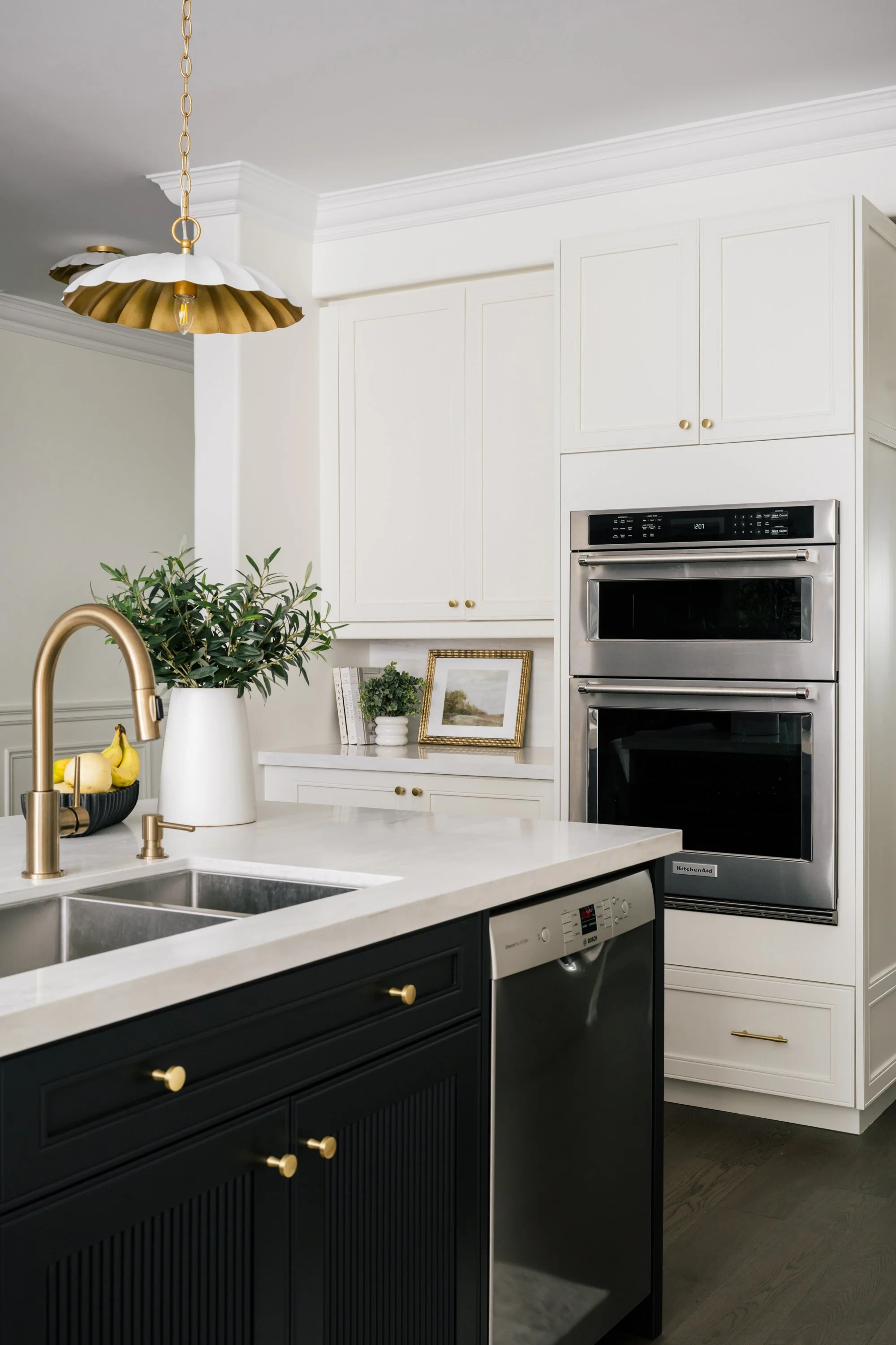 A three-quarter angle of the integrated stove and microwave in the back wall and dishwasher in the kitchen island