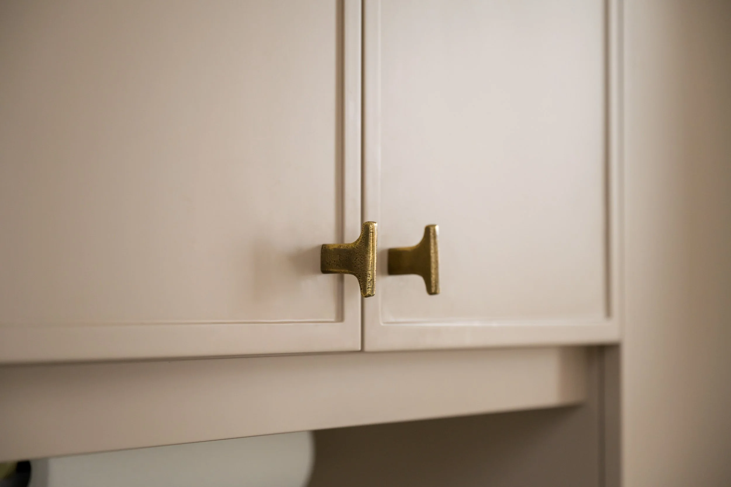 Close up of kitchen upper cabinet door vertical knob