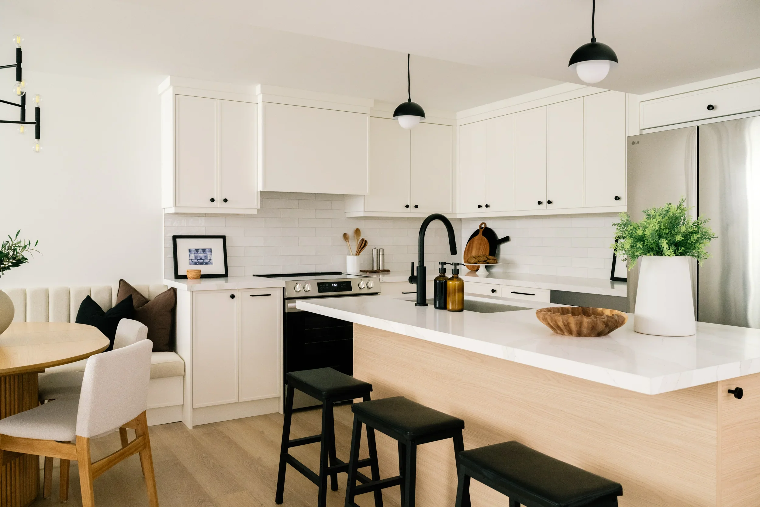 A white kitchen with a kitchen island in a basement