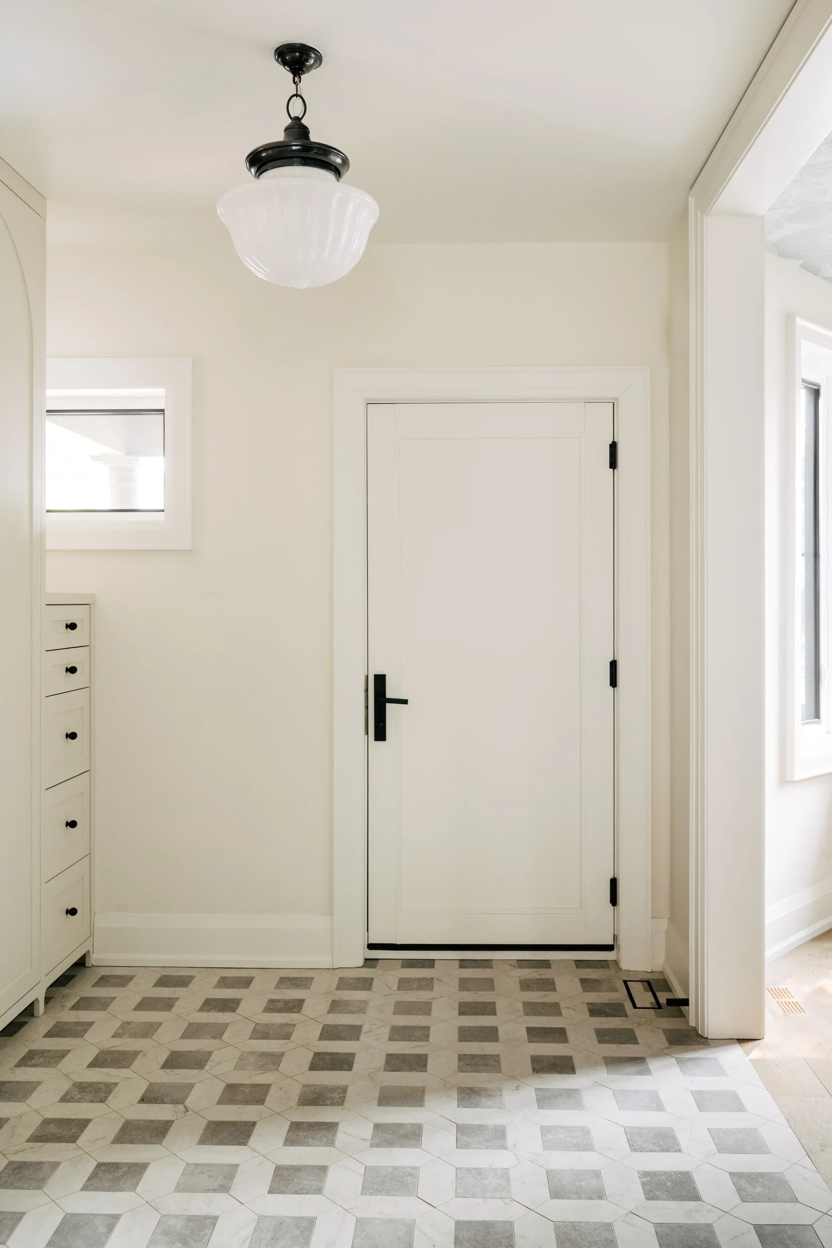 Front door of a foyer with black hardware.