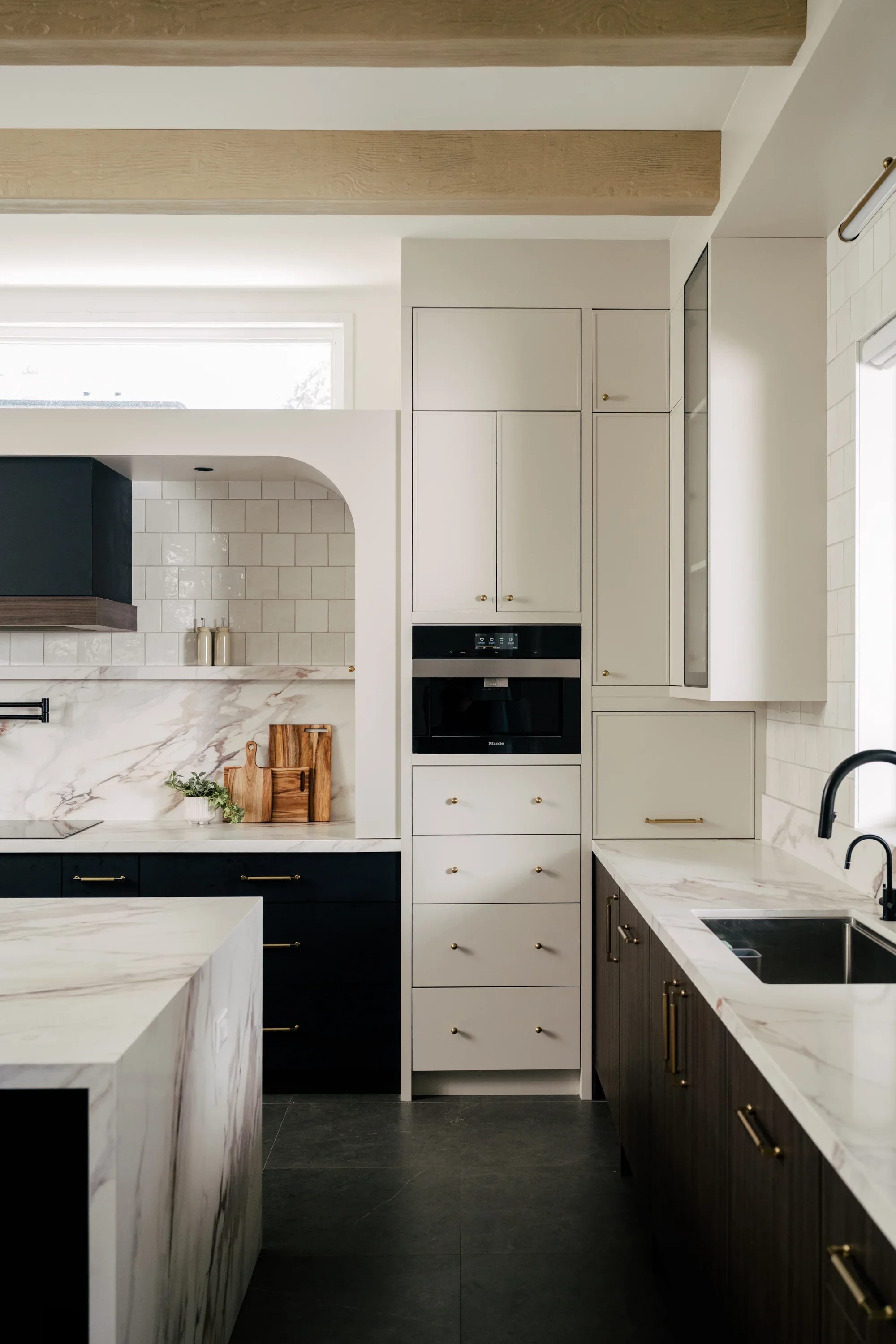 A view of an integrated coffee machine along with cabinets, next to the stove area.