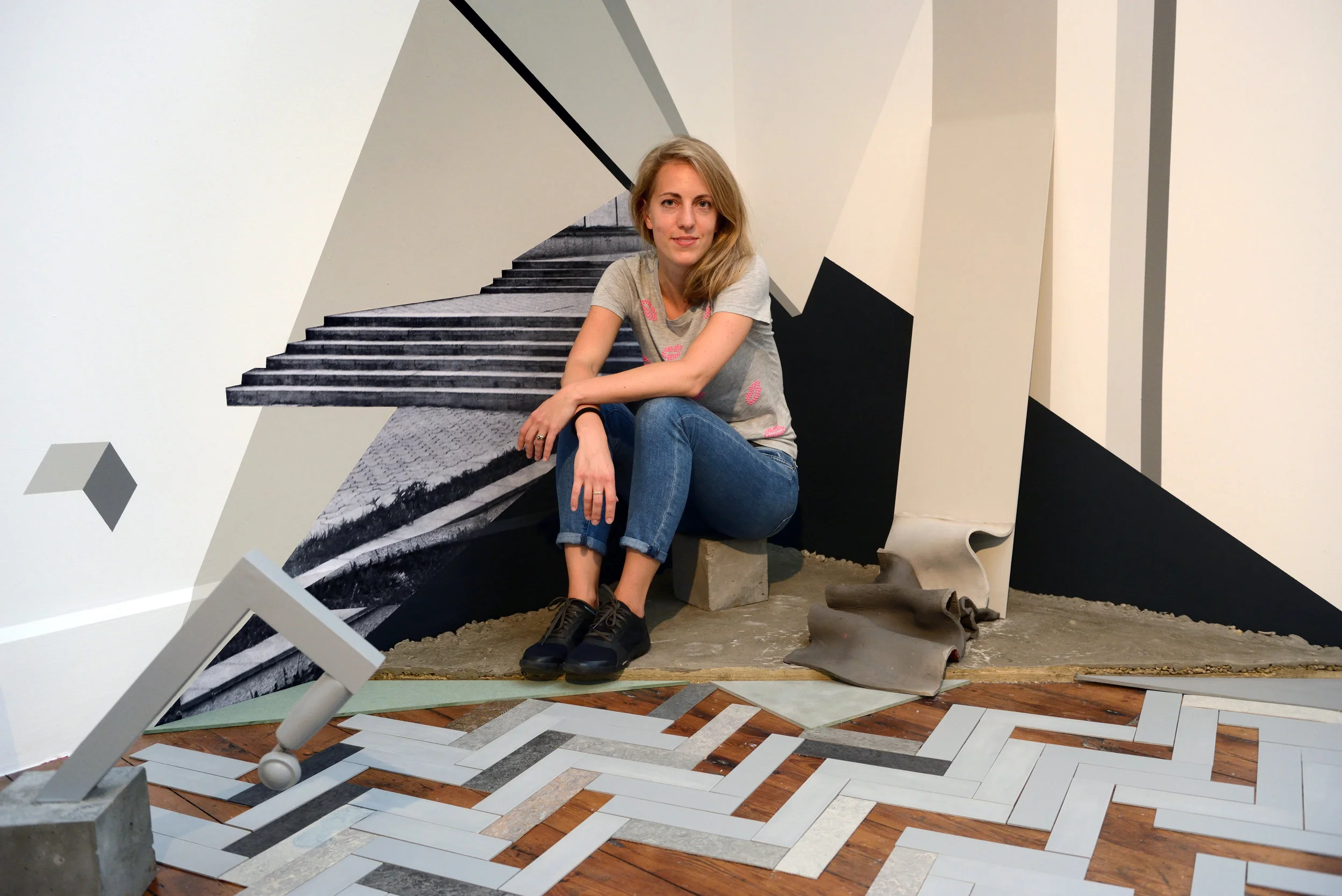 Evy Jokhova in front of 'Sketch for a failure of budgets II'. 2017. Installation view Royal British Society of SculptorsPhoto credit Anne Purkiss