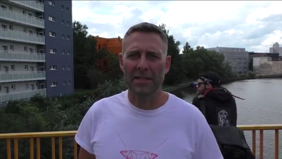 Video still: Marcus Staiger of the BBB gives an interview on Wullenwebersteg on September 10th, 2015, with Englische Strasse 20 in the background. Credit: left report via YouTube